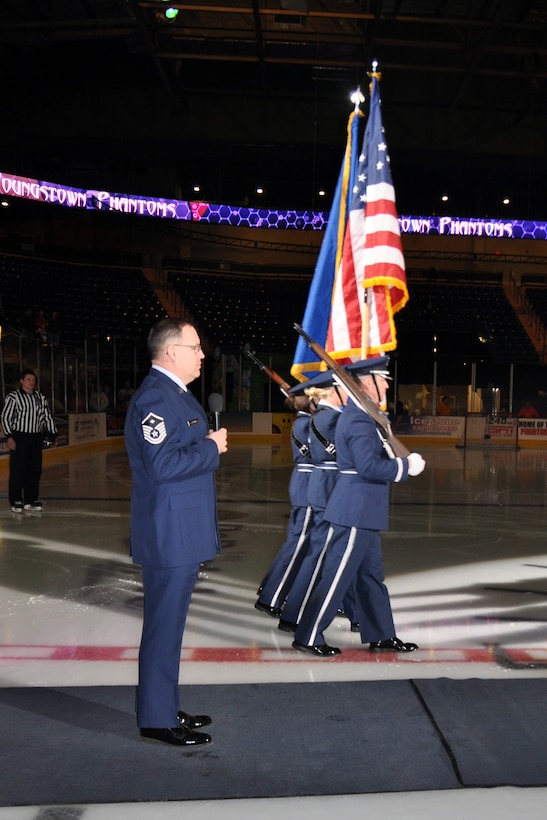 YOUNGSTOWN, Ohio -- Air Force Reserve Master Sgt. Brenton Black, first sergeant of the 76th Aerial Port Squadron, prepares to sing the national anthem as the 910th Airlift Wing Base Honor Guard marches into position to present the colors during pre-game festivities for a Youngstown Phantoms hockey game at the Covelli Centre here, Jan. 8. Sergeant Black and more than 130 Citizen Airmen based at nearby Youngstown Air Reserve Station, Ohio participated in Military Appreciation Night activities before and during the game. The Phantoms, a member of the United States Hockey League, defeated the Muskegon Lumberjacks 4-3 in front of a crowd of more than 1600 people. U.S. Air Force photo by Master Sgt. Bob Barko Jr.