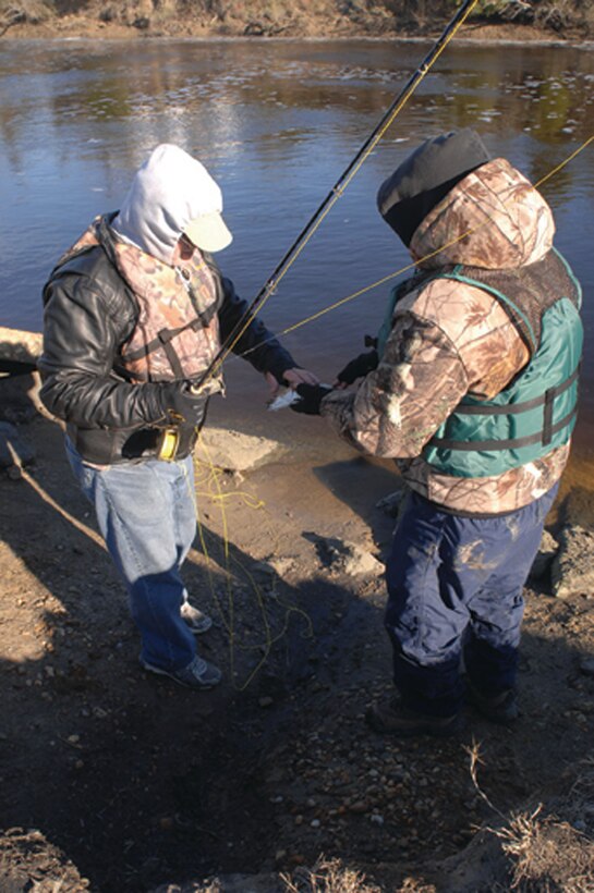A Soldier gives his catch to his volunteer guide for weighing and tagging. The day’s catches were weighed, tagged and released with assistance from the Virginia Institute of Marine Sciences as part of their on-going study of game fish in the Chesapeake Bay.