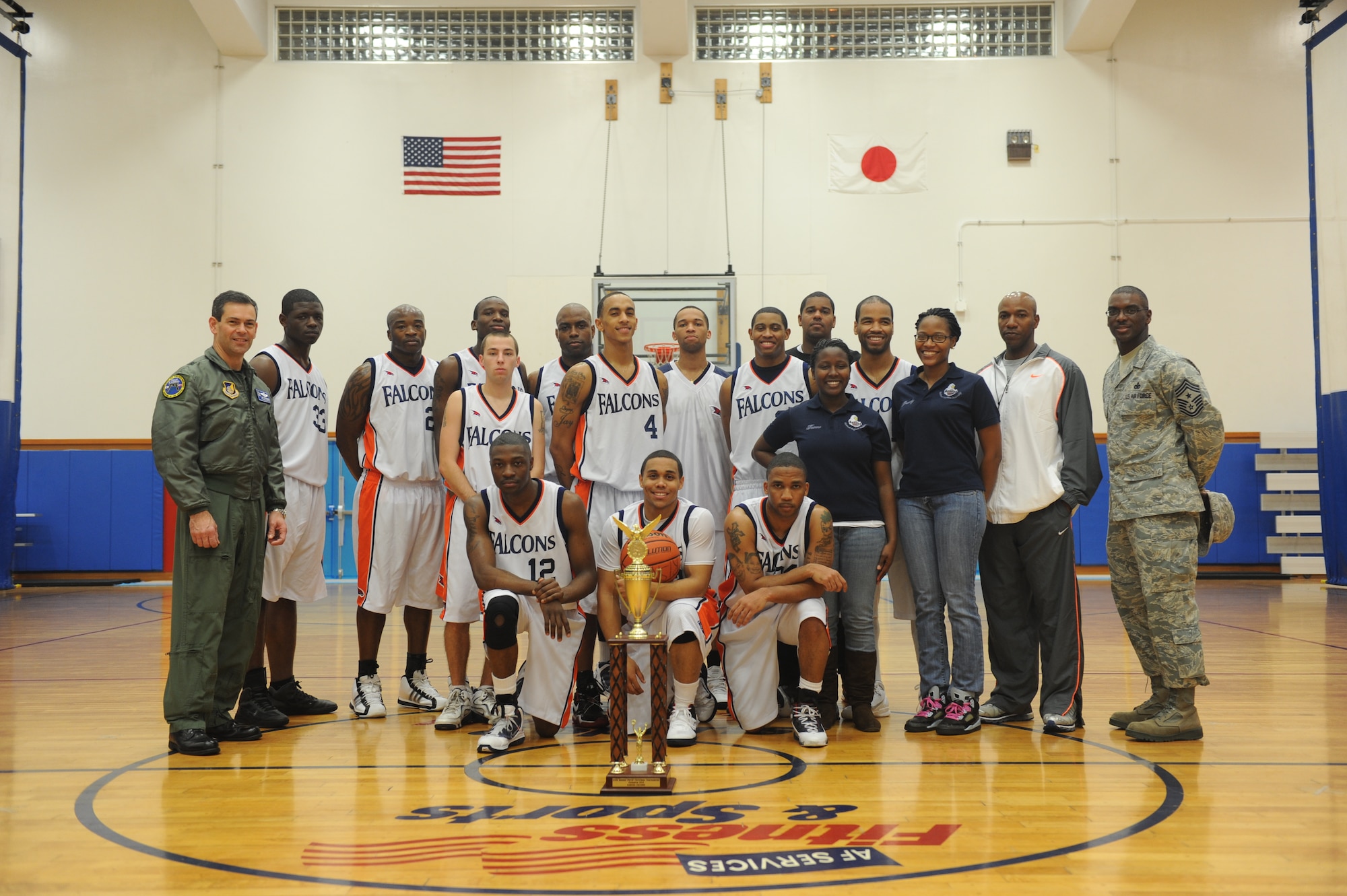 The Kadena Falcons Men’s Varsity Basketball Team stand behind their trophy with Brig Gen. Ken Wilsbach,18th Wing commander and Chief Master Sgt. James Davis, 18th Wing command chief at Kadena Air Base, Jan. 6.The Kadena Falcons Men's Varsity Basketball Team were crowned champions of the Pacific as they defeated the home favorite Osan Defenders 92-82 in the 25th Annual PACAF Christmas Tournament last month at Osan Air Base, Korea. (U.S. Air Force photo/Staff Sgt. Jonathan Steffen)