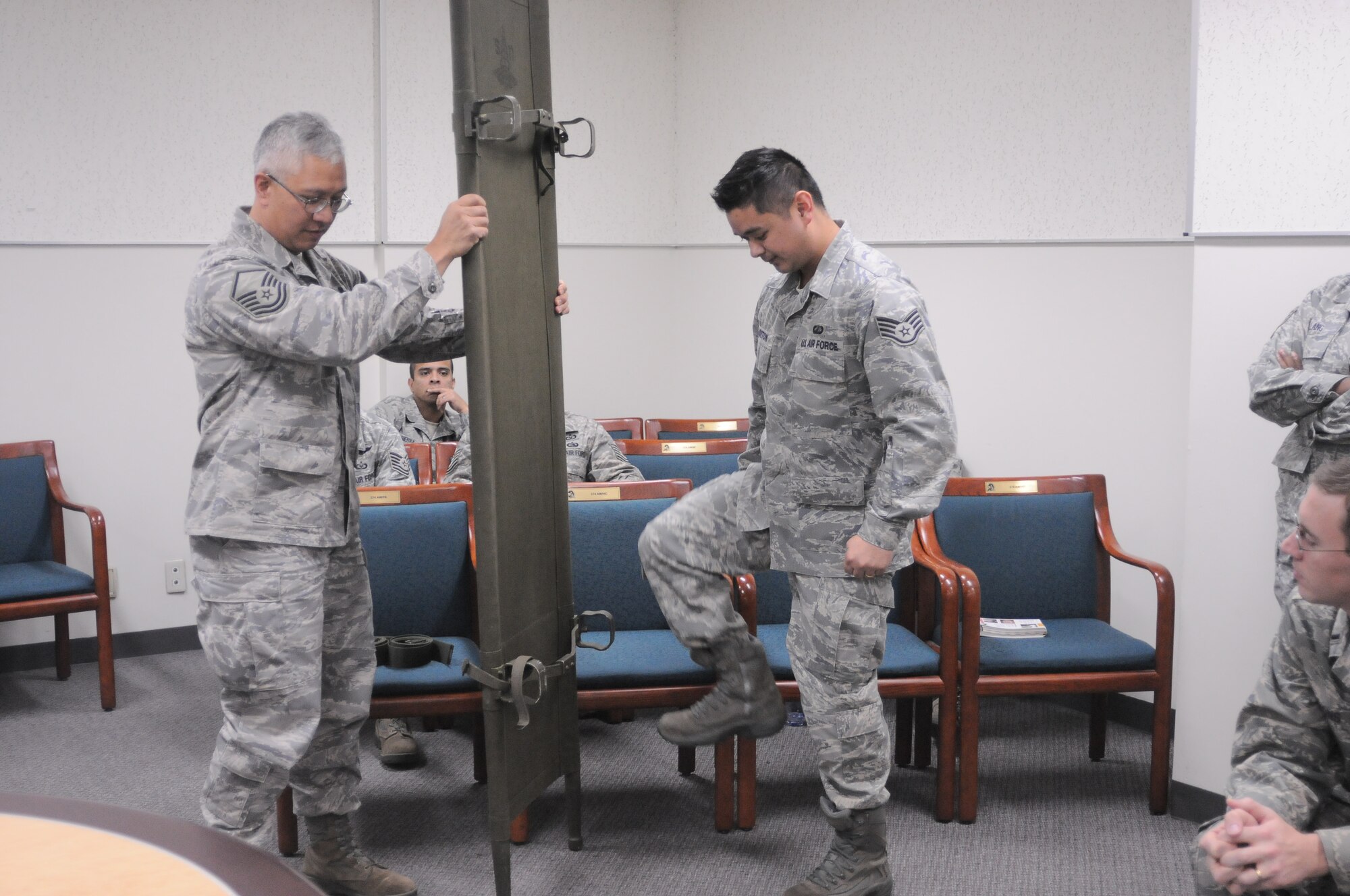 YOKOTA AIR BASE, Japan -- Master Sgt. Darren Lee, 374th Airlift Wing Chapel superintendent chapel operations, (left) and Staff Sgt. Joe Horton, 374th Comptroller Squadron finance customer service technician, demonstrate the proper way to open a litter, here Jan. 07, during the Samurai Readiness Training Day. (U.S. Air Force photo/ Airman 1st Class Katrina R. Menchaca)