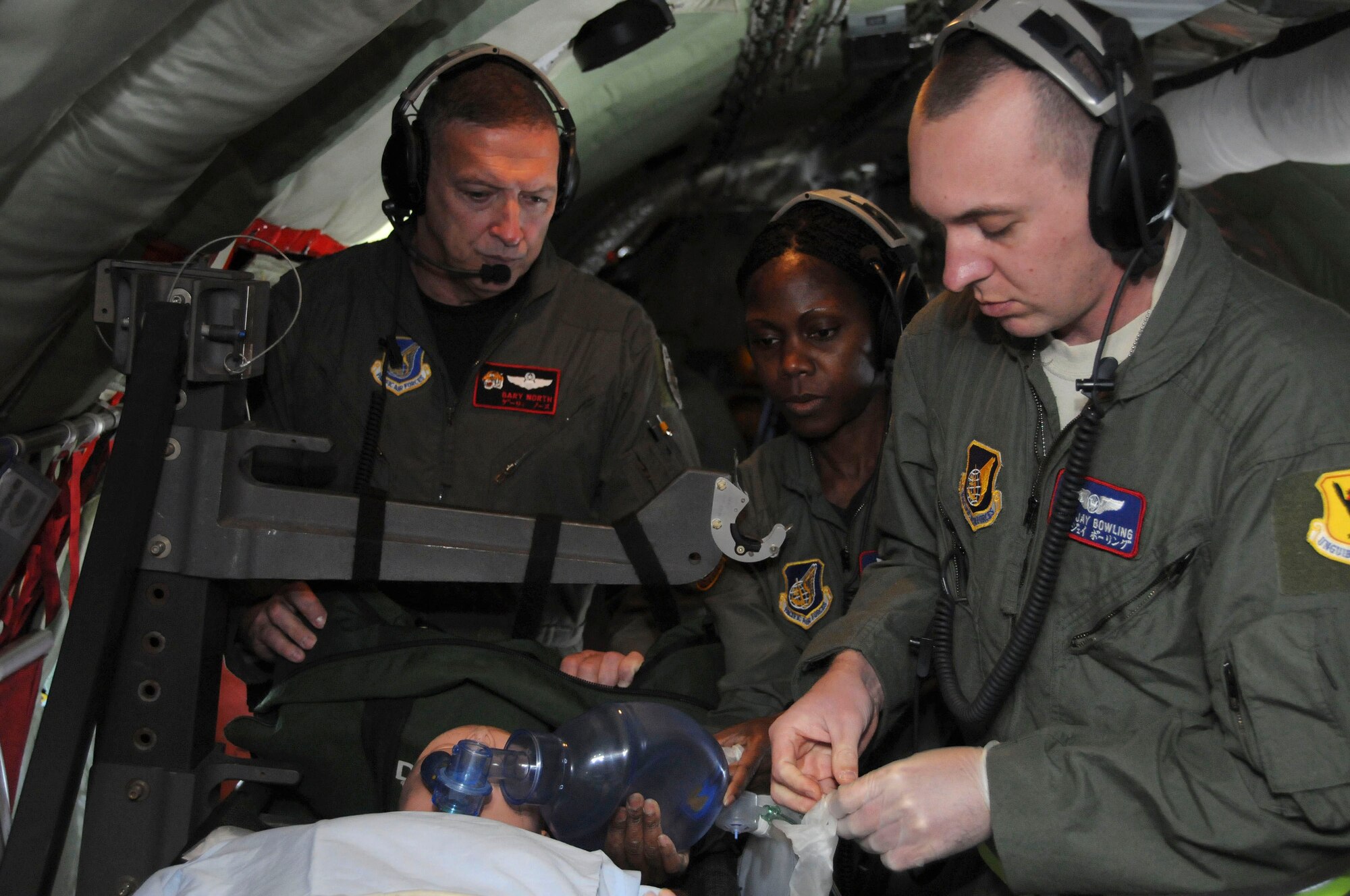 Gen. Gary North, Pacific Air Forces commander, watches a patient care in-flight demonstration performed by Maj. Stephanie Isaac-Francis,and Staff Sgt. Jay Bowling, both with the 18th Aeromedical Evacuation Squadron, during his visit to Kadena Air Base Jan. 10. This demonstration showed General North how the 18th AES provides medical support for patients while onboard an aircraft. (U.S. Air Force photo/Staff Sgt. Darnell T. Cannady)