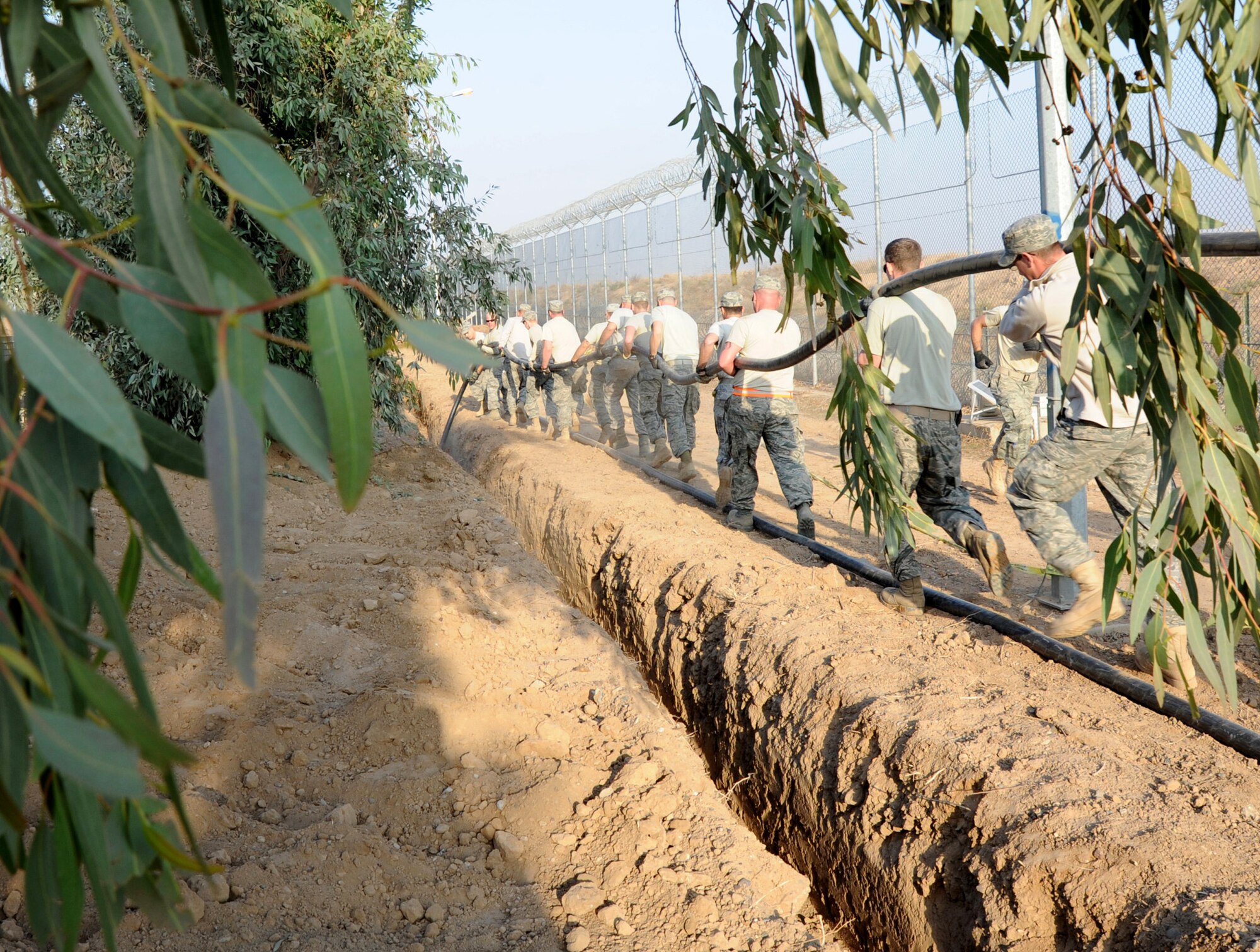 Members of the 332nd Expeditionary Civil Engineer Squadron lay a high-voltage power cable Jan. 6, 2011, at Joint Base Balad, Iraq. The cable will provide power for local villagers who were without power for more than 85 days. (U.S. Air Force photo/Staff Sgt. Keyonna Fennell)