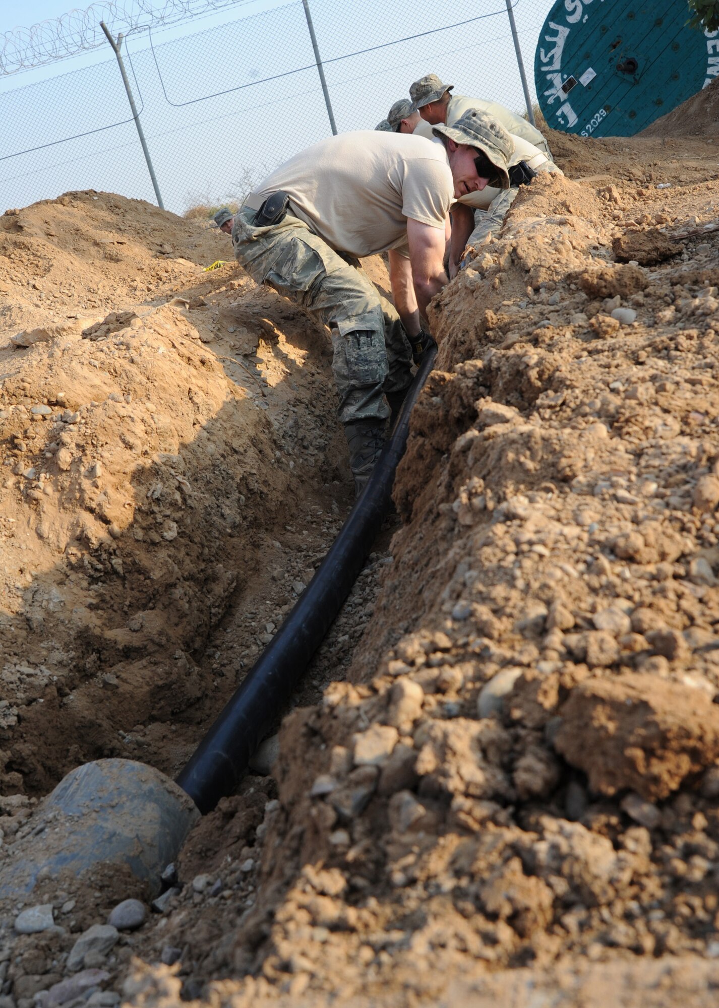 Senior Airman Curtis Raymond lays high-voltage power cable Jan. 6, 2011, at Joint Base Balad, Iraq. The cable will provide electricity for local villagers who were without power for more than 85 days. Airman Raymond is a 332nd Expeditionary Civil Engineer Squadron structural journeyman. (U. S. Air Force photo/Staff Sgt. Keyonna Fennell) 
