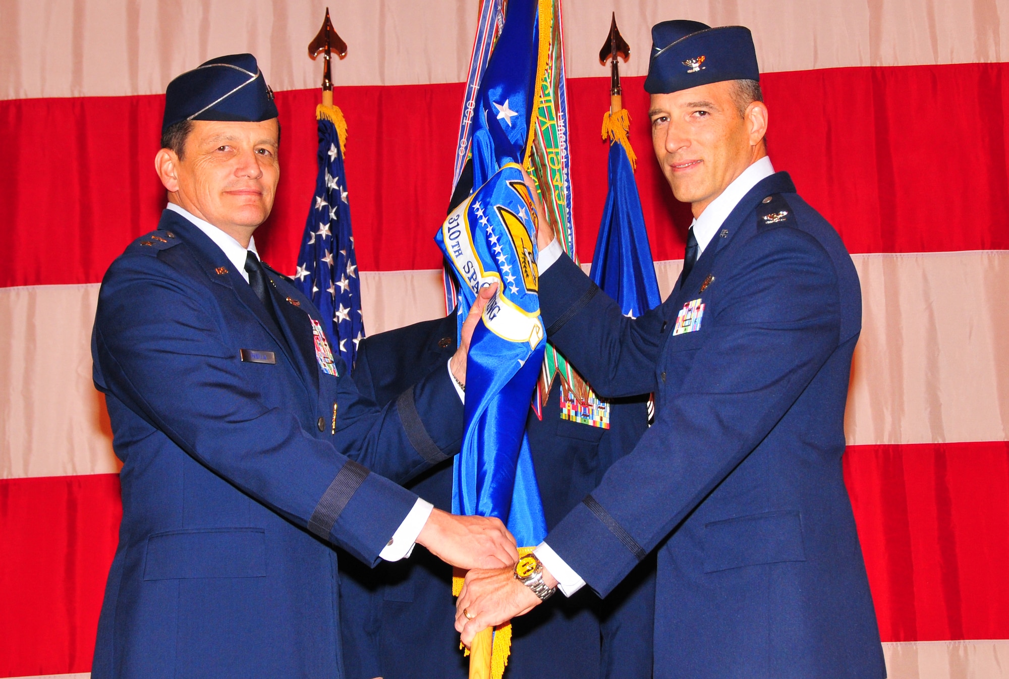 Maj. Gen. Frank J. Padilla, 10th Air Force commander, left, hands the 310th Space Wing flag and command of the Air Force Reserve's only space wing to Colonel Jeffrey "Sal" Mineo. Colonel Mineo became the third commander of the 310th Space Wing during the Jan. 9 ceremony hosted by its sister wing, the 302nd Airlilft Wing at Peterson Air Force Base, Colo. (U.S. Air Force photo/Tech. Sgt. Nick Ontiveros)