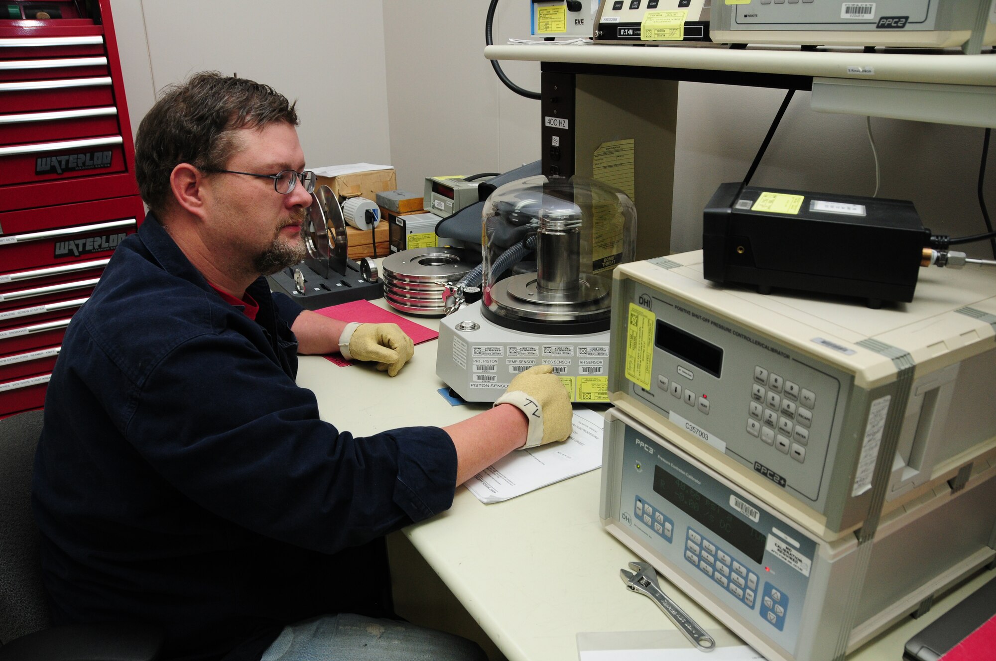 Chris Tvrdik performs a calibration on a digital pressure indicator using a high accuracy pressure standard while working in the Physical Dimensional calibration area.  (U.S. Air Force photo by Master Sgt. Ralph J. Kapustka)  (Released)