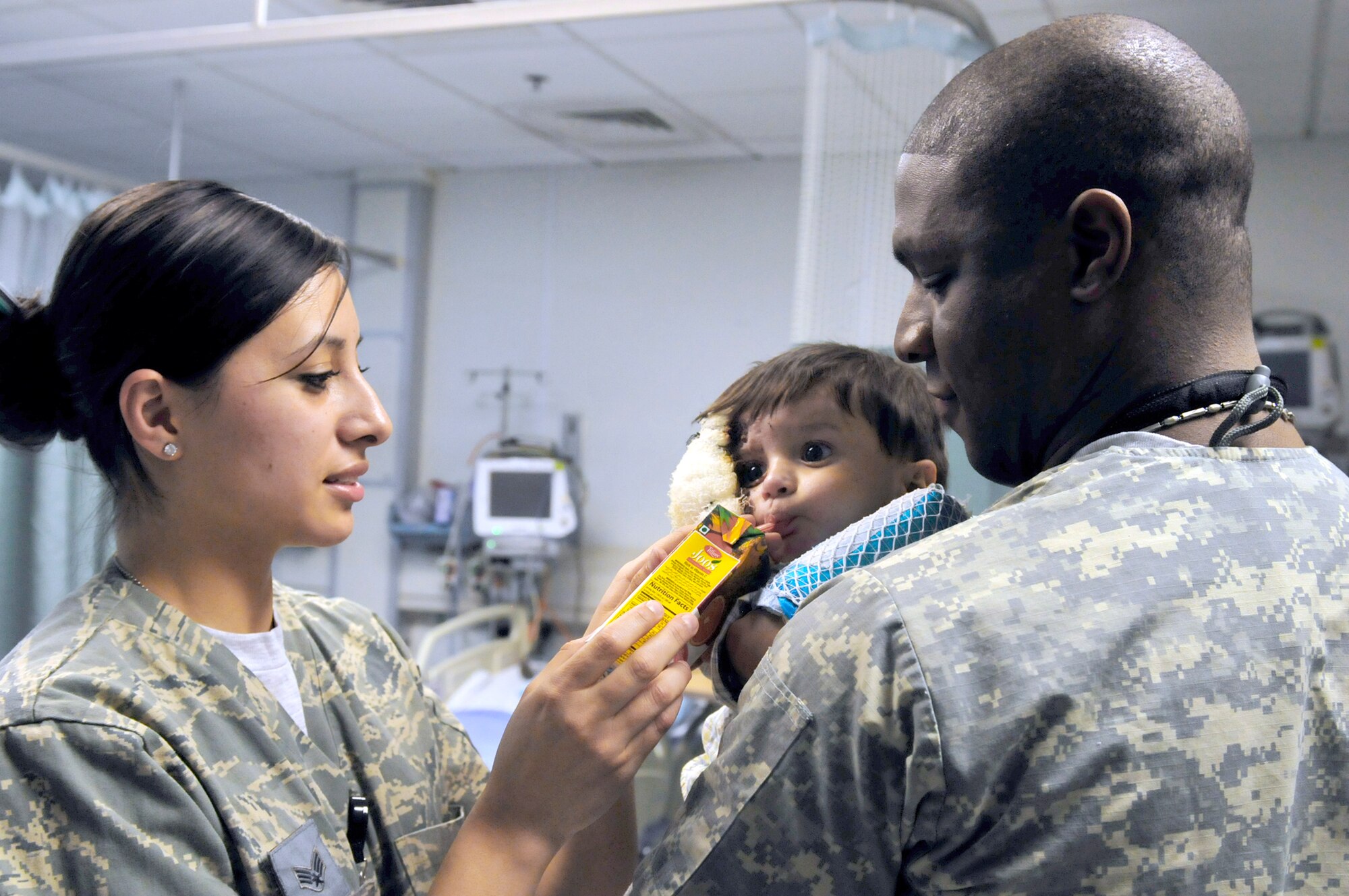 Senior Airmen Mabel Aguirre and Staff Sgt. Dequijamin Roberson tend to Ajamal Hazrat Jan. 9, 2011.  Ajamal was a patient at the Craig Joint Theater Hospital at Bagram Airfield, Afghanistan. He and several members of his family were badly injured after a propane tank used to heat their home exploded. Airman Aguirre and Sergeant Roberson are medical technicians assigned to the 455th Expeditionary Medical Operation Squadron. (U.S. Air Force photo/Tech. Sgt. Michael Voss)