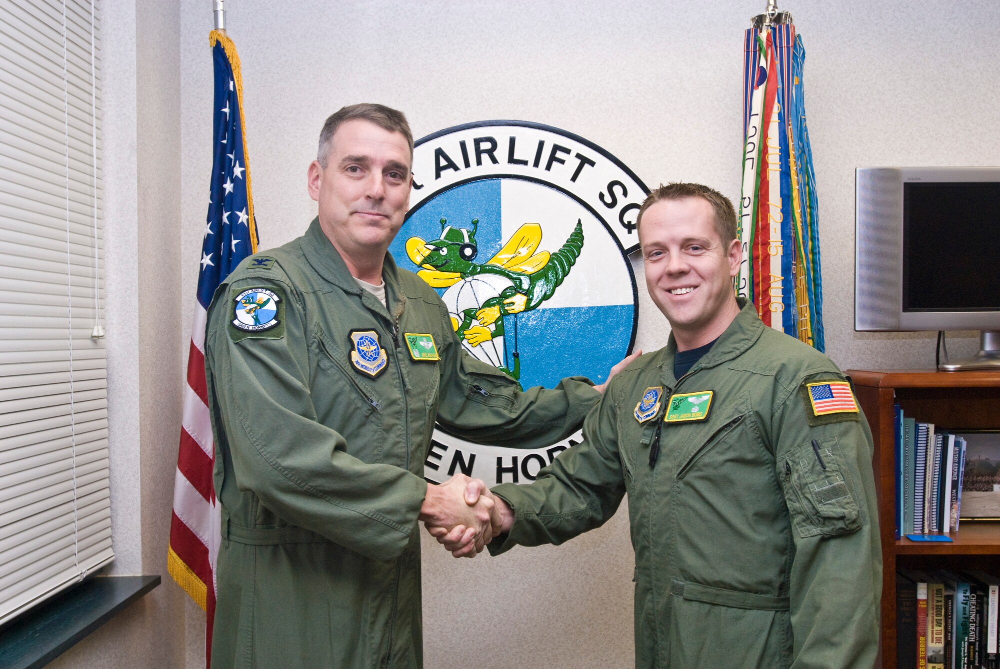 Col. Mike Minihan (left), 19th Airlift Wing commander, presents a coin Dec. 14, 2010, to Staff Sgt. Jason Bobo, a 61st Airlift Squadron instructor flight engineer, for his selection as the Combat Airlifter of the Week at Little Rock Air Force Base, Ark. Sergeant Bobo exceeded all expectations during a recent Joint Readiness Training Center exercise by developing and managing an essential VHF communication link between aircraft, maintenance and support Airmen. (U.S. Air Force photo by Staff Sgt. Nestor Cruz)