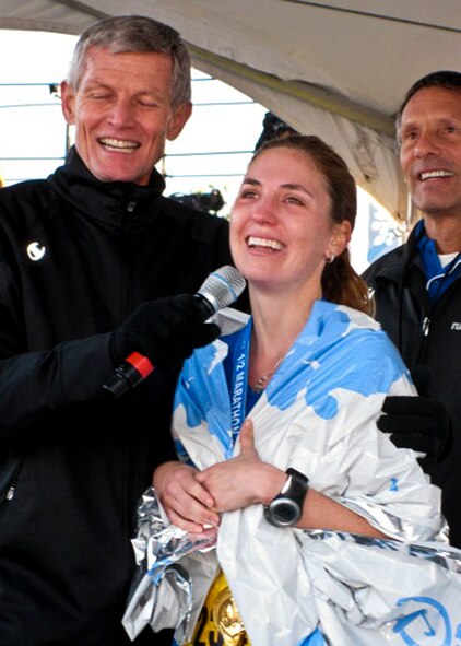 Lynette Traynor reacts to seeing her husband, Maj. Devin Traynor, 46th Operations Group, on a huge screen at Disney World Jan, 8. 2011. She had just completed a half marathon with him via GPS while he was serving in Iraq. They were able to see each other at the end through a video link. (Courtesy photo) 