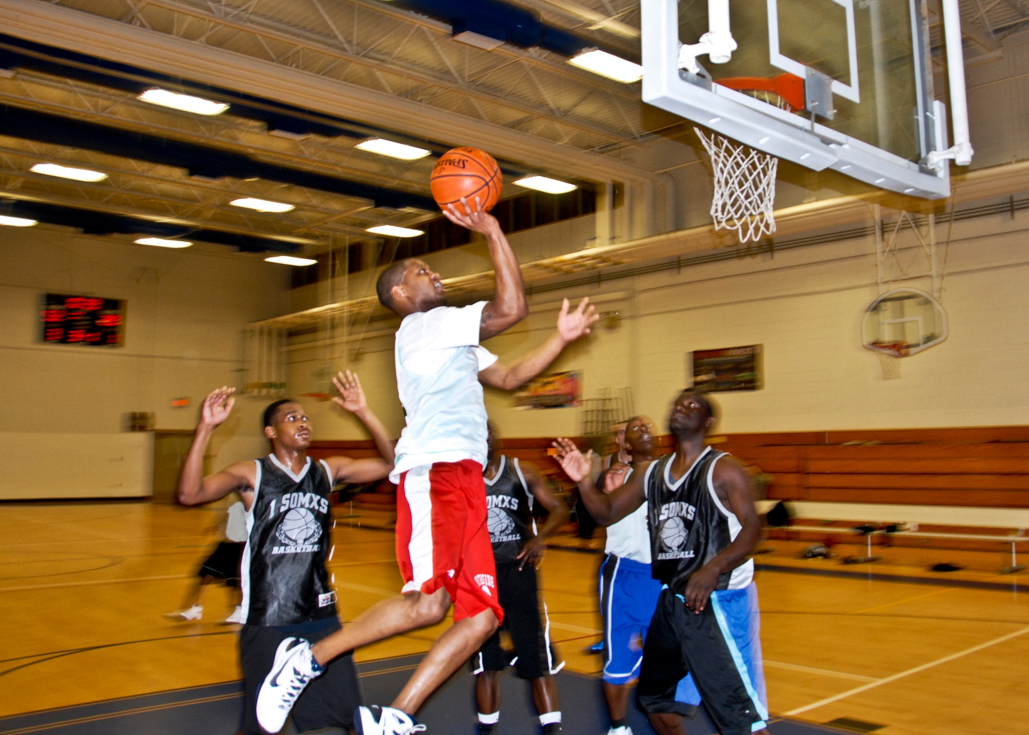Wendell Thibeaux, 96th Medical Group, takes to the air for a layup against the 1st Special Operations Maintenance Squadron team during the 2011 intramural basketball playoffs Jan. 10.  The 96 MDG team won the playoff opener, 65-43.  (U.S. Air Force photo/Kevin Gaddie) 
