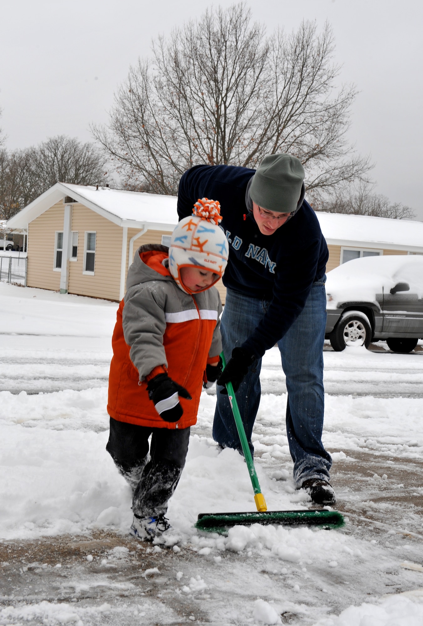 Staff Sgt. Adam Kidney, 19th Aircraft Maintenance Squadron unit deployment manager, shovels snow with his son, Eli, 4, from the sidewalk of his house Jan. 10, 2011, at Little Rock Air Force Base, Ark. This day brought the first winter storm of 2011, with an accumulation of approximately two inches of snow. (U.S. Air Force photo by Senior Airman Gul Crockett)