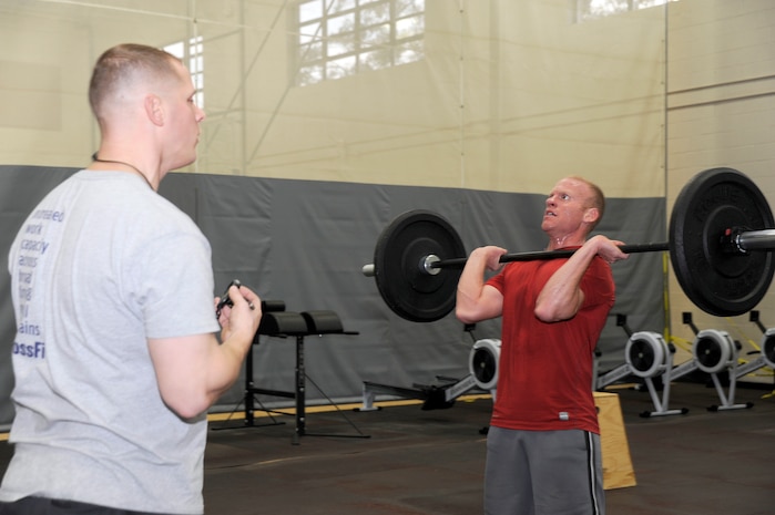 Scott Levesque watches as Douglas Ryan performs "hang cleans" during the CrossFit instructor course at the Fitness and Sports Center Jan. 5, 2011. The Fitness and Sports Center will hopefully be offering CrossFit classes towards the latter part of January for active duty military which are planned to be a 30-minute, high-intensity workout. Levesque is assigned to the 628th Communications Squadron and Ryan is assigned to the 628th Civil Engineer Squadron as an explosive ordnance disposal technician.(U.S. Air Force photo/Staff Sgt. Marie Brown)