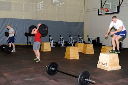 Joint Base Charleston members perform a timed routine consisting of three different exercises during the CrossFit instructor course at the Fitness and Sports Center Jan. 5, 2011. Members who attended the CrossFit instructor course performed three rounds of 20 repetitions of "box jumps", "wall balls" and "hang cleans" which consisted of 60 total repetitions per exercise, 180 for workout total. (U.S. Air Force photo/Staff Sgt. Marie Brown)