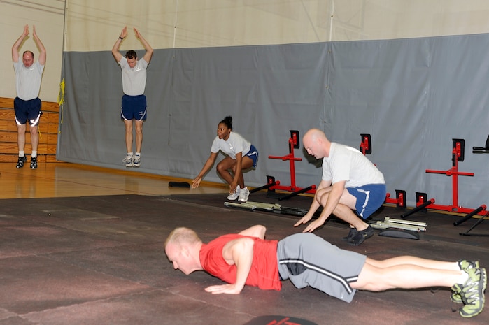 Members of Joint Base Charleston perform warm-up exercises prior to the start of the CrossFit instructor course at the Fitness and Sports Center Jan. 5, 2011. This was the first instructor course offered which brought in 13 potential instructors for upcoming CrossFit classes. The fitness center staff will narrow down the 13 potential instructors to two who will attend a CrossFit level 1 certification course in Charlotte, N.C. in Feb. (U.S. Air Force photo/Staff Sgt. Marie Brown)