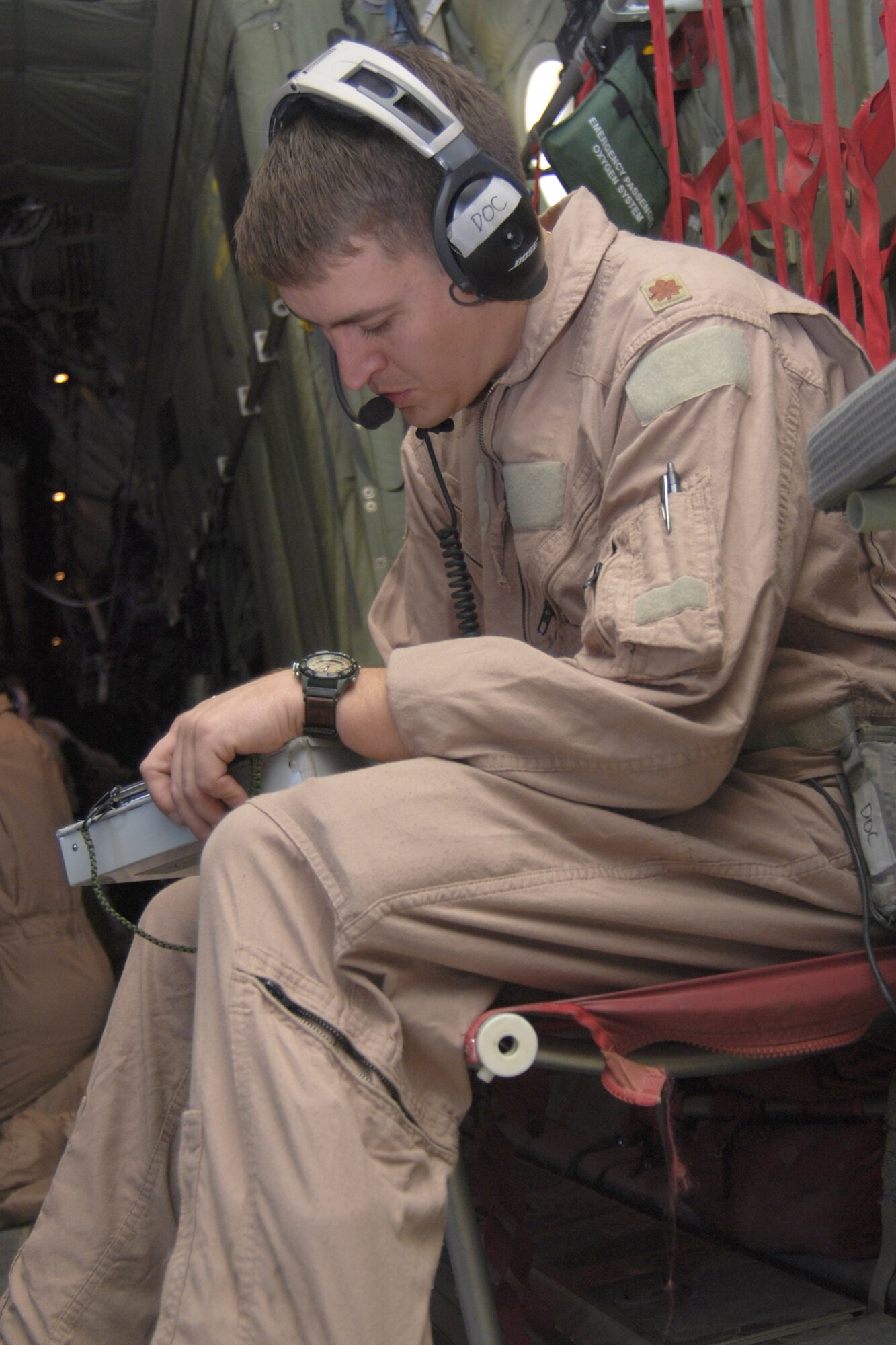 As a critical care air transport team member Maj. (Dr.) George Kotti makes notes on a patient's medical chart inside a C-130H-Hercules Jan. 5, 2011. The CCATT is a specialized three-person team that recreates an intensive care unit environment within an aircraft during aeromedical evacuations. Dr. Kotti is assigned to the 451st Aeromedical Evacuation Squadron . (U.S. Air Force photo/Senior Airman Melissa B. White)