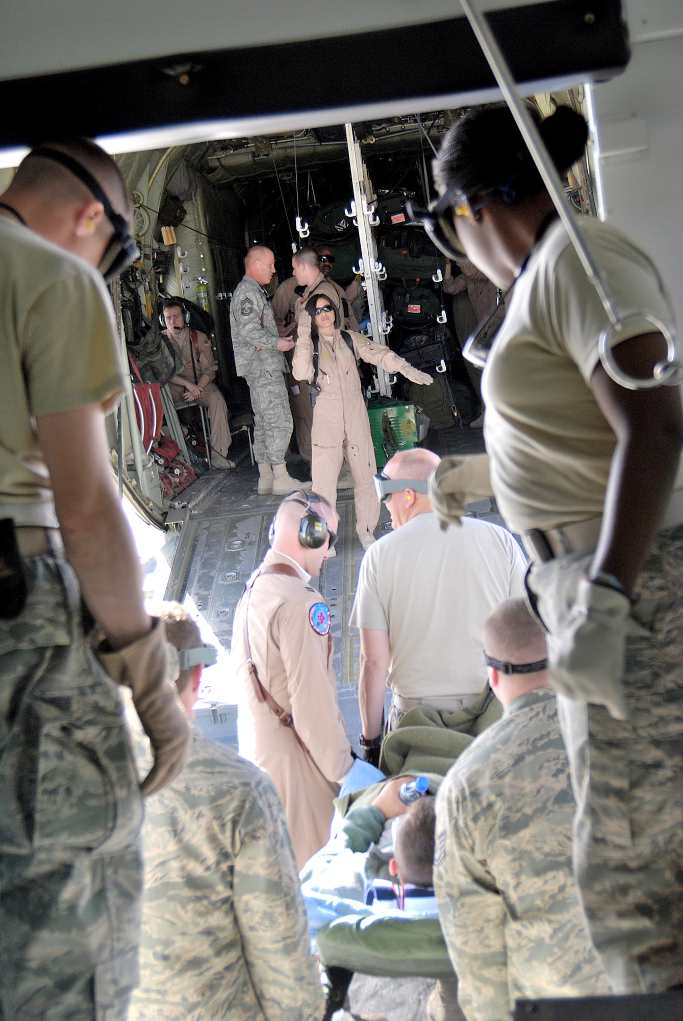 Members of the 451st Expeditionary Aeromedical Evacuation Squadron Critical Care Air Transport Team work together to load patients onto a C-130H Hercules for an aeromedical evacuation Jan. 5, 2011, at Kandahar Airfield, Afghanistan. The CCATT is a specialized three-person team that recreates an intensive care unit environment within an aircraft during aeromedical evacuations. (U.S. Air Force photo/Senior Airman Melissa B. White)