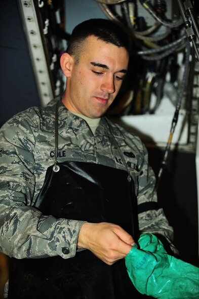 DYESS AIR FORCE BASE, Texas—Airman First Class Rick Cole, 7th Aircraft Maintenance Unit, puts on protective gear Jan. 10  before working on a B-1 Bomber in the three bay hanger here. From Pittsburgh Airman Cole has spent 10 months at Keesler and Sheppard Air Force Base for training, and has been at Dyess three months. Airman Cole is one of approximately 30 electronic warfare specialists stationed here. (Air Force photo/ Airman First Class Courtney Moses)