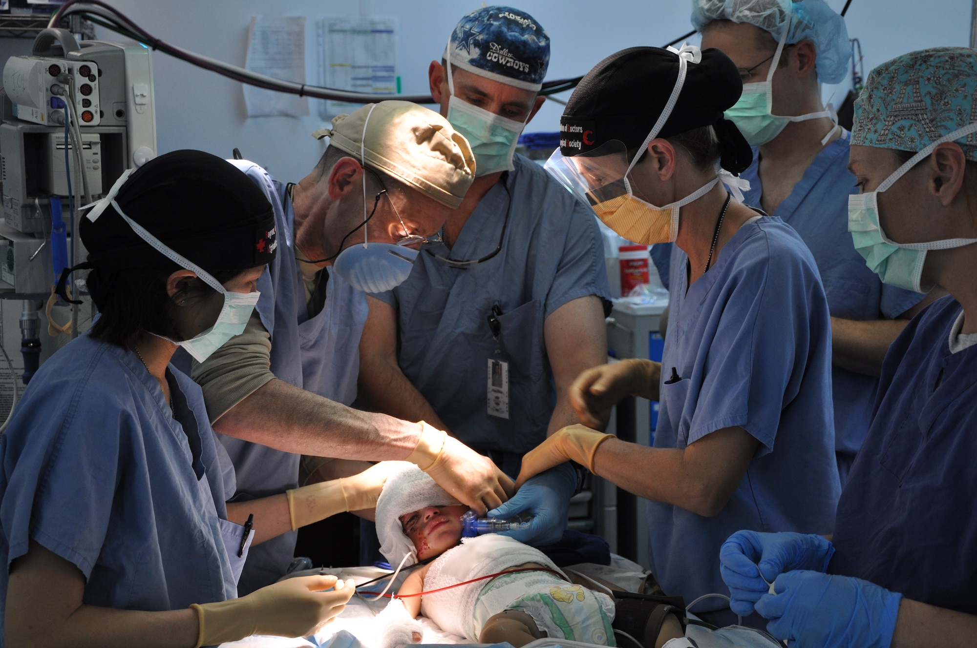 A Craig Joint Theater Hospital medical team wraps new bandages on a 12-month-old Afghan boy during a procedure in the operating room. The boy was brought to the hospital with significant burns from a propane tank explosion at his home in Kapisa Province.  (U.S. Air Force photo by Capt. Erick Saks) 
