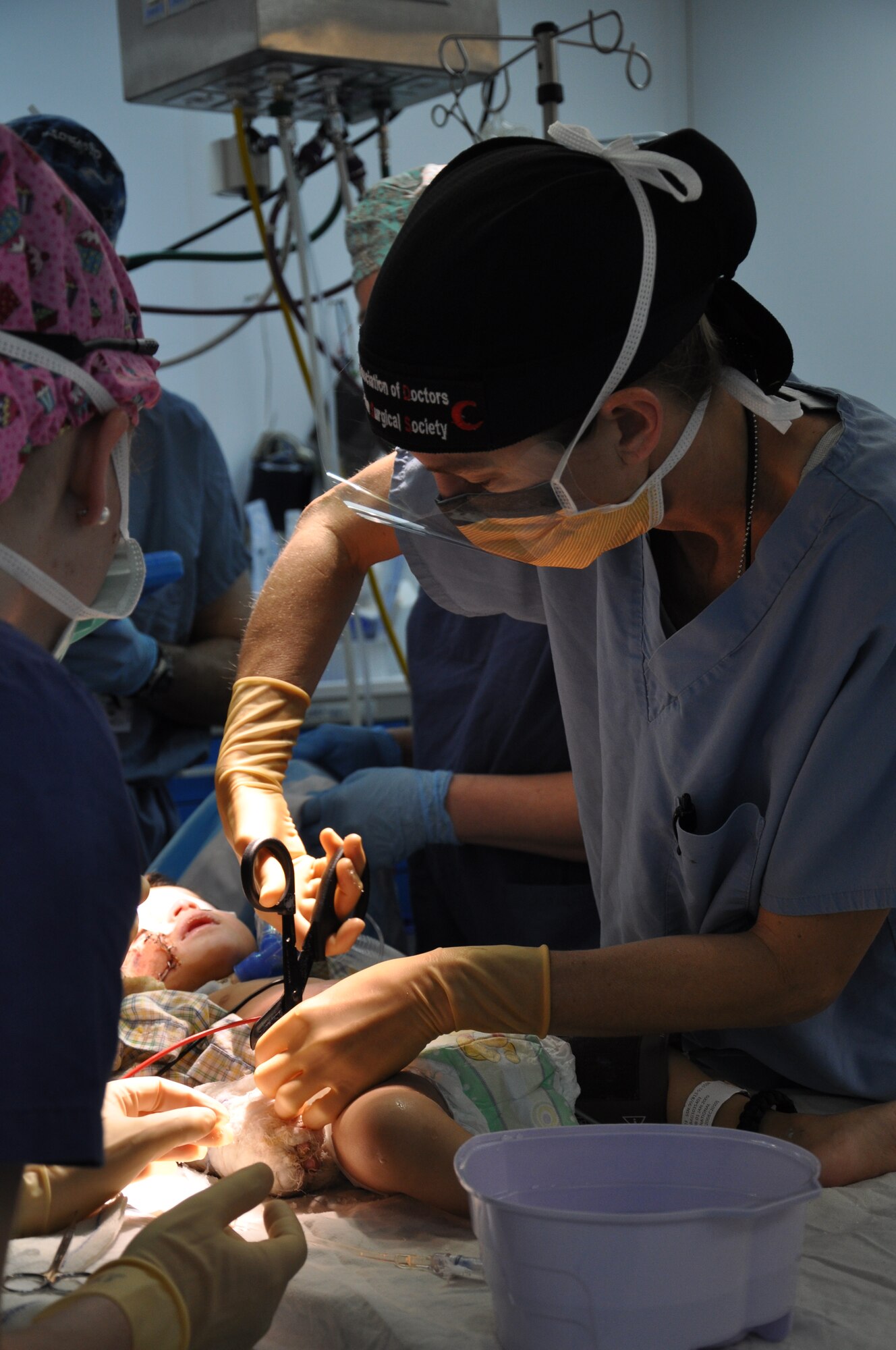 A doctor at the Craig Joint Theater Hospital removes the cast from a 12-month-old Afghan child who received significant burns from a propane tank explosion at his home in Kapisa Province.  (U.S. Air Force photo by Capt. Erick Saks) 