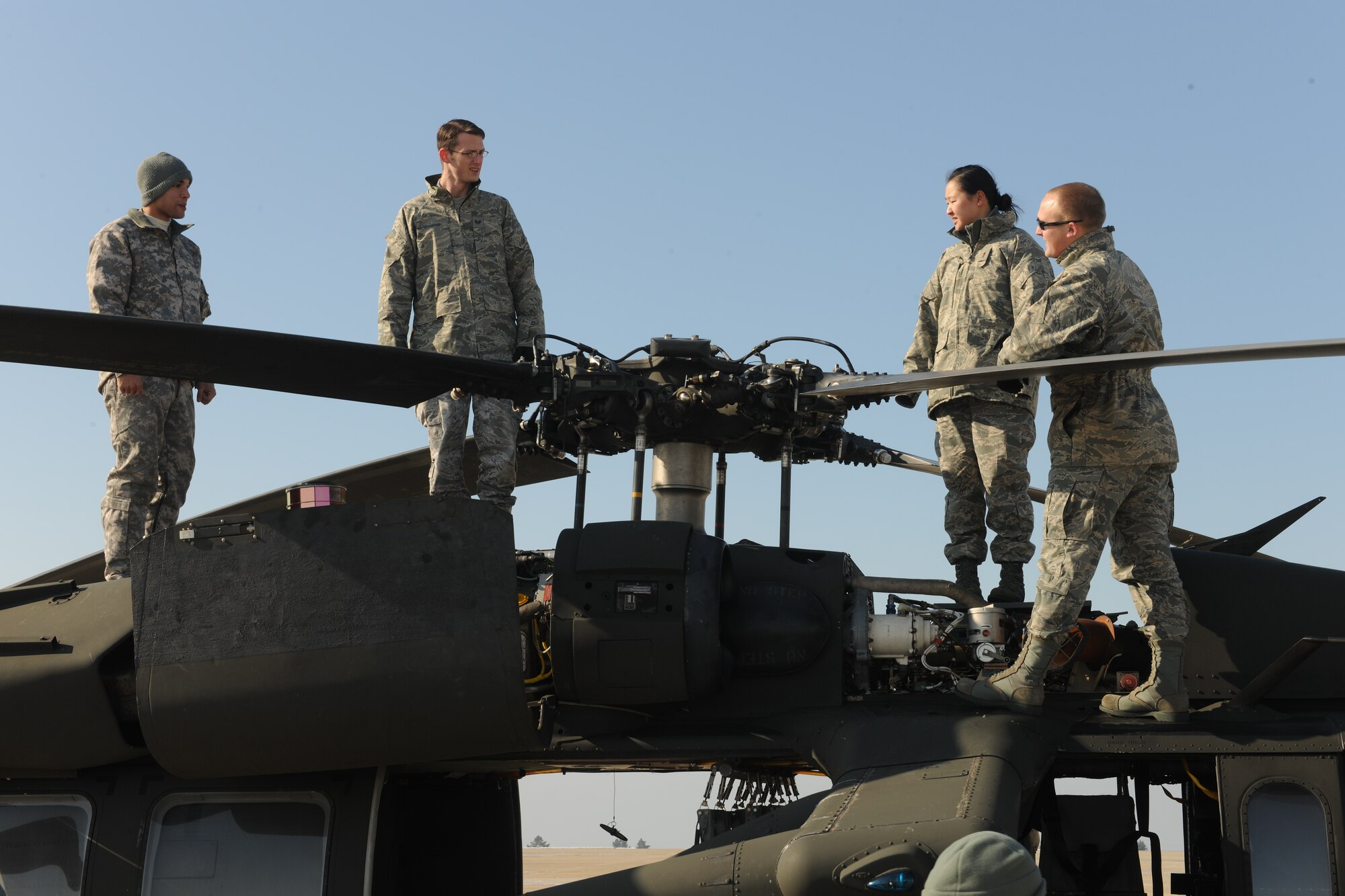 KUNSAN AIR BASE, Republic of Korea -- Private First Class George Oberg, Black Hawk maintainer from the 2-2 Aviation Regiment, 2nd Combat Aviation Brigade at Camp Humphreys, Republic of Korea, talks with Wolf Pack Airmen about the Black Hawk on the flightline here Jan. 7. Capt. Lee Jin, 8th Fighter Wing ground liaison officer, invited a Black Hawk team here from Camp Humphreys to educate Wolf Pack pilots and 8th Operations Group intelligence Airmen on Army aviation assets. (U.S. Air Force/Senior Airman Ciara Wymbs)