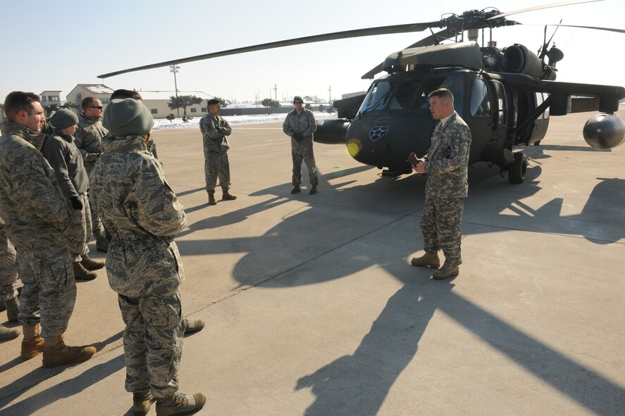 KUNSAN AIR BASE, Republic of Korea -- Army Chief Warrant Officer Craig Parker, a UH-60 Black Hawk pilot from the 2-2 Aviation Regiment, 2nd Combat Aviation Brigade at Camp Humphreys, Republic of Korea, talks to Wolf Pack Airmen about the Black Hawk on the flightline here Jan. 7. Capt. Lee Jin, 8th Fighter Wing ground liaison officer, invited a Black Hawk team here from Camp Humphreys to educate Wolf Pack pilots and 8th Operations Group intelligence Airmen on Army aviation assets. (U.S. Air Force/Senior Airman Ciara Wymbs)