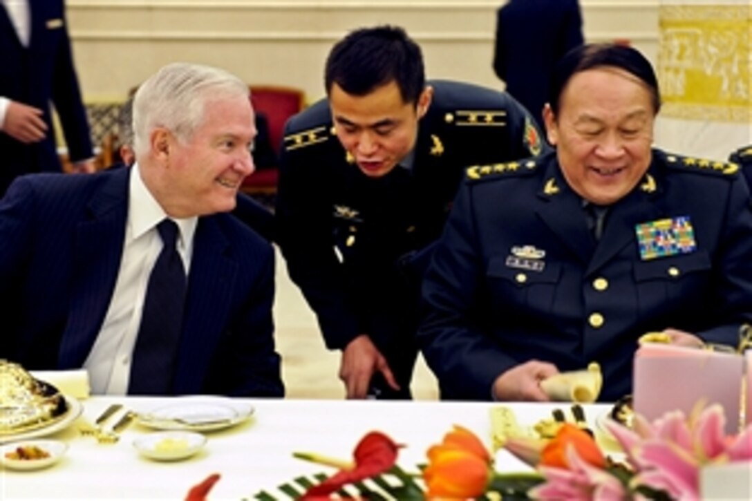 U.S. Defense Secretary Robert M. Gates and Chinese Defense Minister Liang Guanglie talk with each other at a luncheon honoring Gates' visit to Beijing, Jan. 10, 2011.