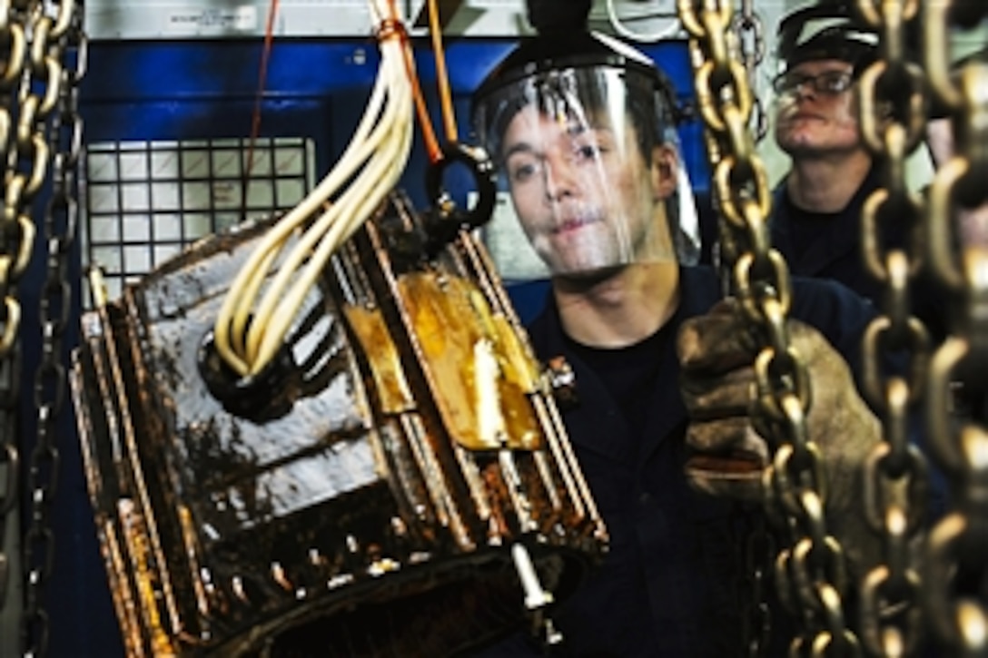 U.S. Navy photo Seaman Cory M. Smith and Petty Officer 3rd Class Ryne M. McReynolds transport a ventilation motor after it was dipped in varnish in the repair shop aboard the aircraft carrier USS Ronald Reagan in the Pacific Ocean, Jan. 10, 2011.