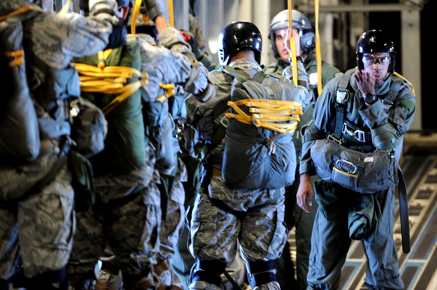 Members of the 36th Contingency Response Group conduct static line jump training from a Hickam C-17 over Andersen Air Base, Guam, Jan. 11. Aircrews from the 535th Airlift Squadron dropped nine training pallets during a single day of training before prviding airlift for the 36th CRG jumpers. (U.S. Air Force photo/Staff Sgt. Mike Meares)