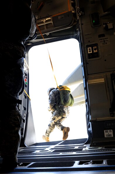Members of the 36th Contingency Response Group conduct static line jump training from a Hickam C-17 over Andersen Air Base, Guam, Jan. 11. Aircrews from the 535th Airlift Squadron dropped nine training pallets during a single day of training before prviding airlift for the 36th CRG jumpers. (U.S. Air Force photo/Staff Sgt. Mike Meares)