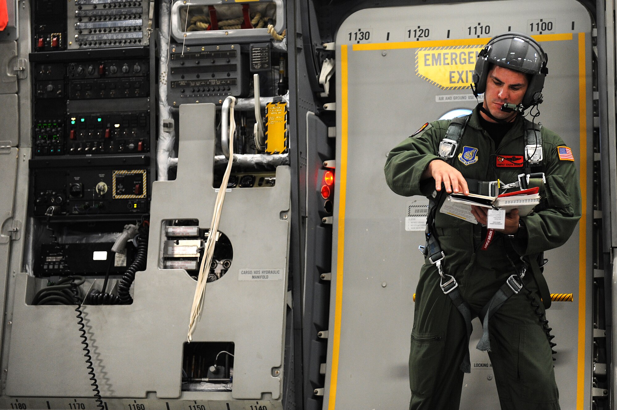Senior Master Sgt. Chuck Baker, 535th Airlift Squadron, goes over airdrop checklist during flight operations on a C-17 Globemaster III perparing for a follow-on airdrop training operations over Andersen Air Base, Guam. Aircrews from the 535th AS dropped nine training pallets during a single day of training. The aircrew then helped the 36th Contingency Response Group with static line jump training. (U.S. Air Force photo/Staff Sgt. Mike Meares)