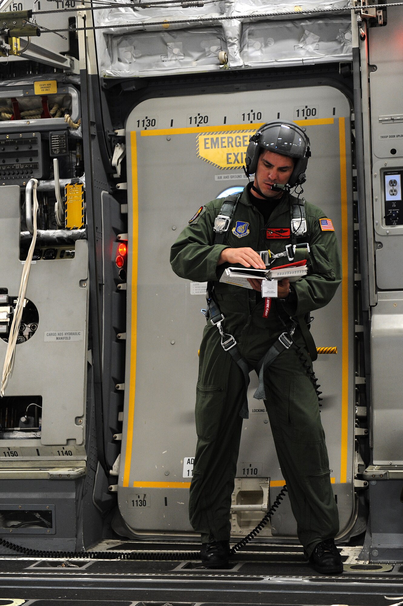 Senior Master Sgt. Chuck Baker, 535th Airlift Squadron, goes over airdrop checklist during flight operations on a C-17 Globemaster III perparing for a follow-on airdrop training operations over Andersen Air Base, Guam. Aircrews from the 535th AS dropped nine training pallets during a single day of training. The aircrew then helped the 36th Contingency Response Group with static line jump training. (U.S. Air Force photo/Staff Sgt. Mike Meares)
