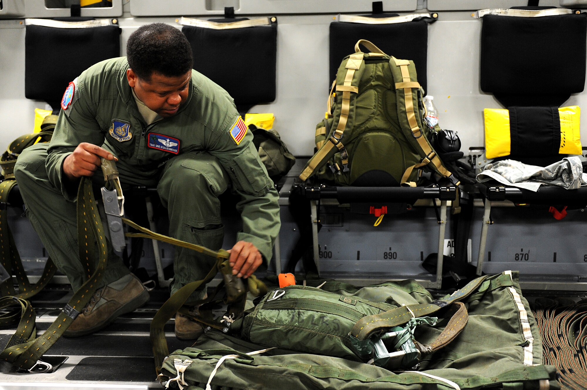 Tech. Sgt. Dre Stollenwerck, 535th Airlift Squadron, prepares a parachute for an airdrop mission over Andersen Air Base, Guam. Aircrews from the 535th AS dropped nine training pallets during a single day of airdrop training. The aircrew then helped the 36th Contingency Response Group with static line jump training. (U.S. Air Force photo/Staff Sgt. Mike Meares)