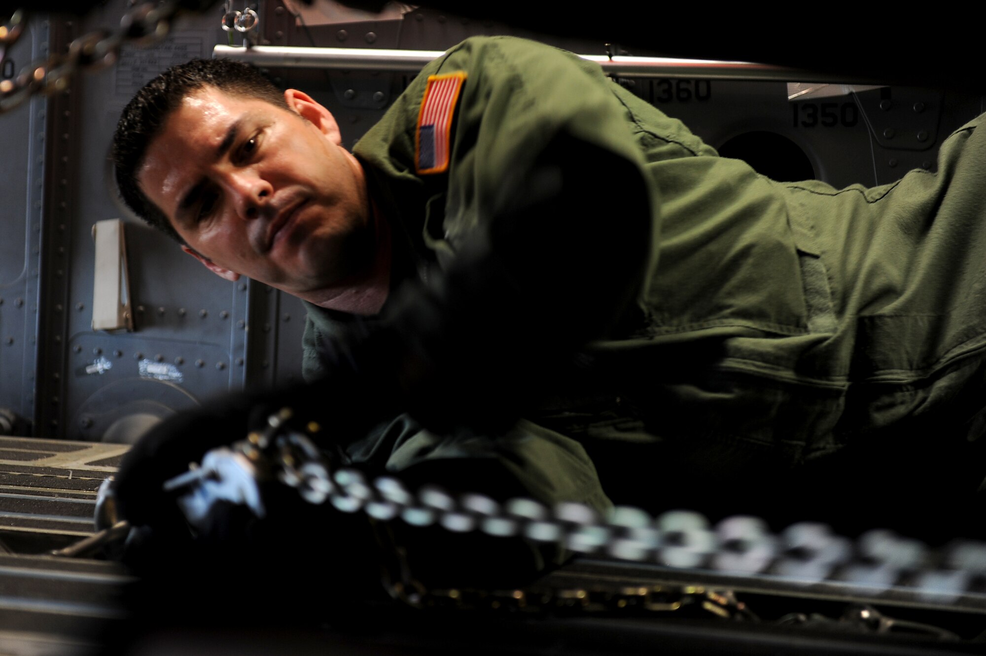 Senior Master Sgt. Chuck Baker, 535th Airlift Squadron,ties down a government vehicle to a C-17 Globemaster III perparing for airdrop training operations over Andersen Air Base, Guam, Jan. 10. Aircrews from the 535th AS dropped nine training pallets during a single day of training. The aircrew then helped the 36th Contingency Response Group with static line jump training. (U.S. Air Force photo/Staff Sgt. Mike Meares)