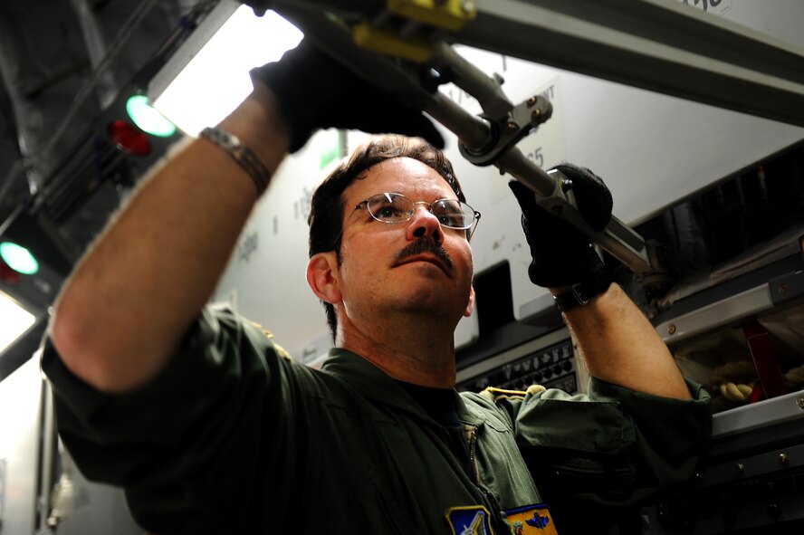 Master Sgt. Brian Chewning, 535th Airlift Squadron, secures the static lines on a C-17 Globemaster III perparing for airdrop training operations over Andersen Air Base, Guam. Aircrews from the 535th AS dropped nine training pallets during a single day of training. The aircrew then helped the 36th Contingency Response Group with static line jump training. (U.S. Air Force photo/Staff Sgt. Mike Meares)