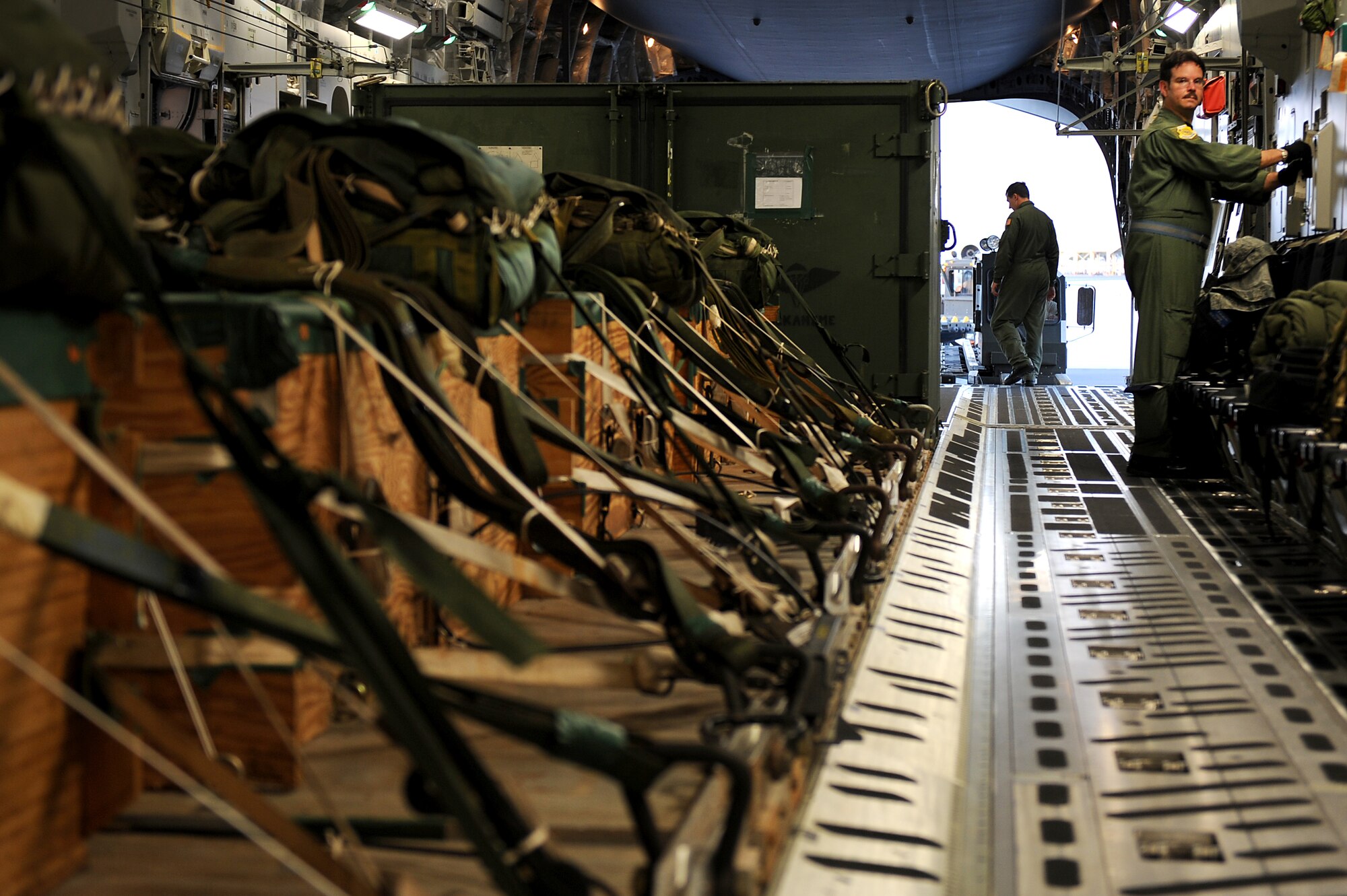 Master Sgt. Brian Chewning, 535th Airlift Squadron loadmaster, works to secure airdrop training pallets prior to taking off for Andersen Air Base, Guam. Aircrews from the 535th AS dropped nine training pallets during a single day of training. The aircrew then helped the 36th Contingency Response Group with static line jump training. (U.S. Air Force photo/Staff Sgt. Mike Meares)
