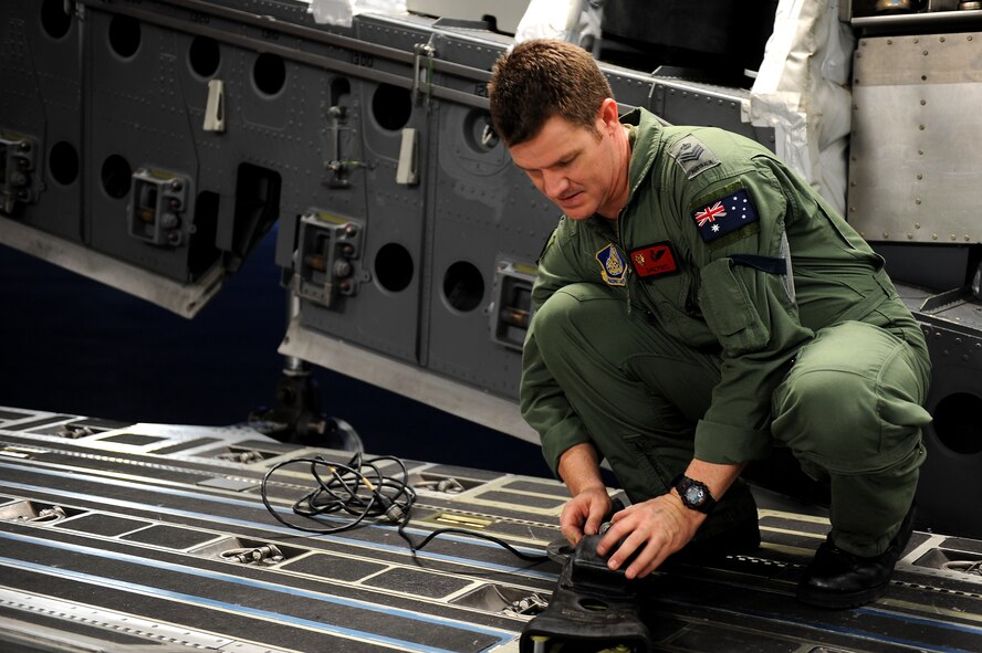 Royal Australian Air Force Flight Sgt. Dave Pyatt, 535th Airlift Squadron loadmaster, prepares tie downs for the container delivery system Jan. 11. Aircrews from the 535th AS dropped nine training pallets during a single day of training. The aircrew then helped the 36th Contingency Response Group with static line jump training. Flight Sergeant Pyatt has been assigneed to the 535th AS as part of an exchange program with the U.S. Air Force for the past three years. (U.S. Air Force photo/Staff Sgt. Mike Meares)