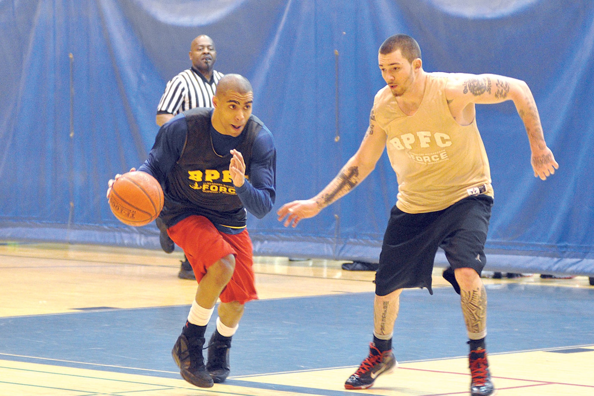 Aaron Green, 98th Maintenance Company, pushes the ball upcourt against 1-40th Cavalry’s Dennis Vosberry. (U.S. Air Force photo/John Pennell)