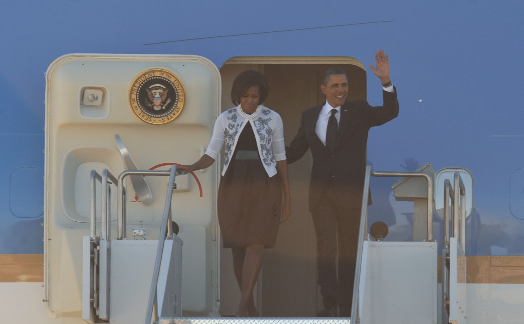 DAVIS-MONTHAN AIR FORCE BASE, Ariz. - President Barack Obama and First Lady Michelle Obama wave to D-M Airmen and members of the local media after landing here Jan. 12. The President and the First Lady arrived at D-M before traveling to attend the memorial service commemorating the six lives lost Jan. 8 in Tucson, Ariz.. (U.S. Air Force photo/ Senior Airman Brittany Dowdle)