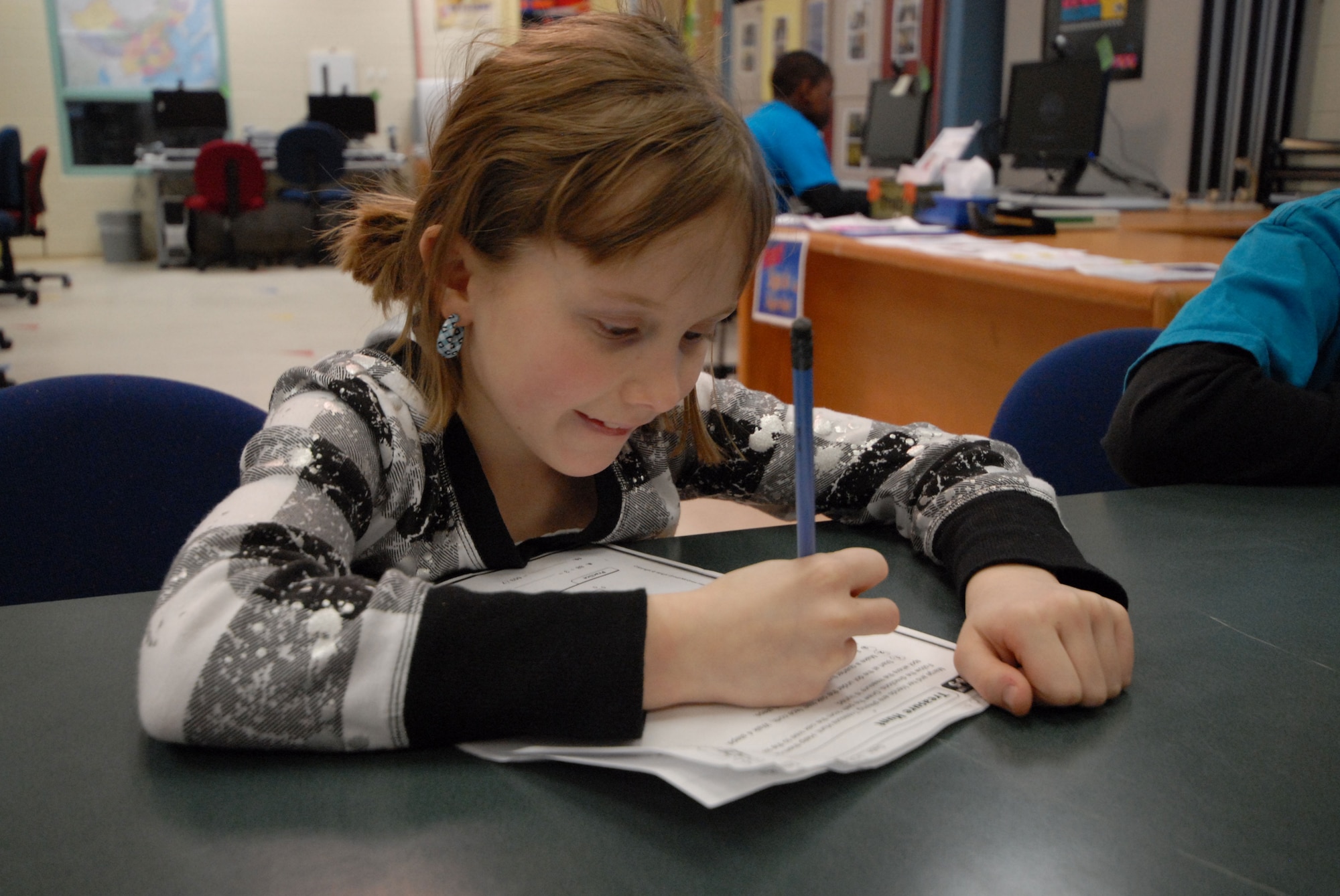 Nine-year-old Kodi Payne works on her homework assignments, Jan. 11, at the Two Rivers Youth Center.  (U.S. Air Force photo/Steve White)