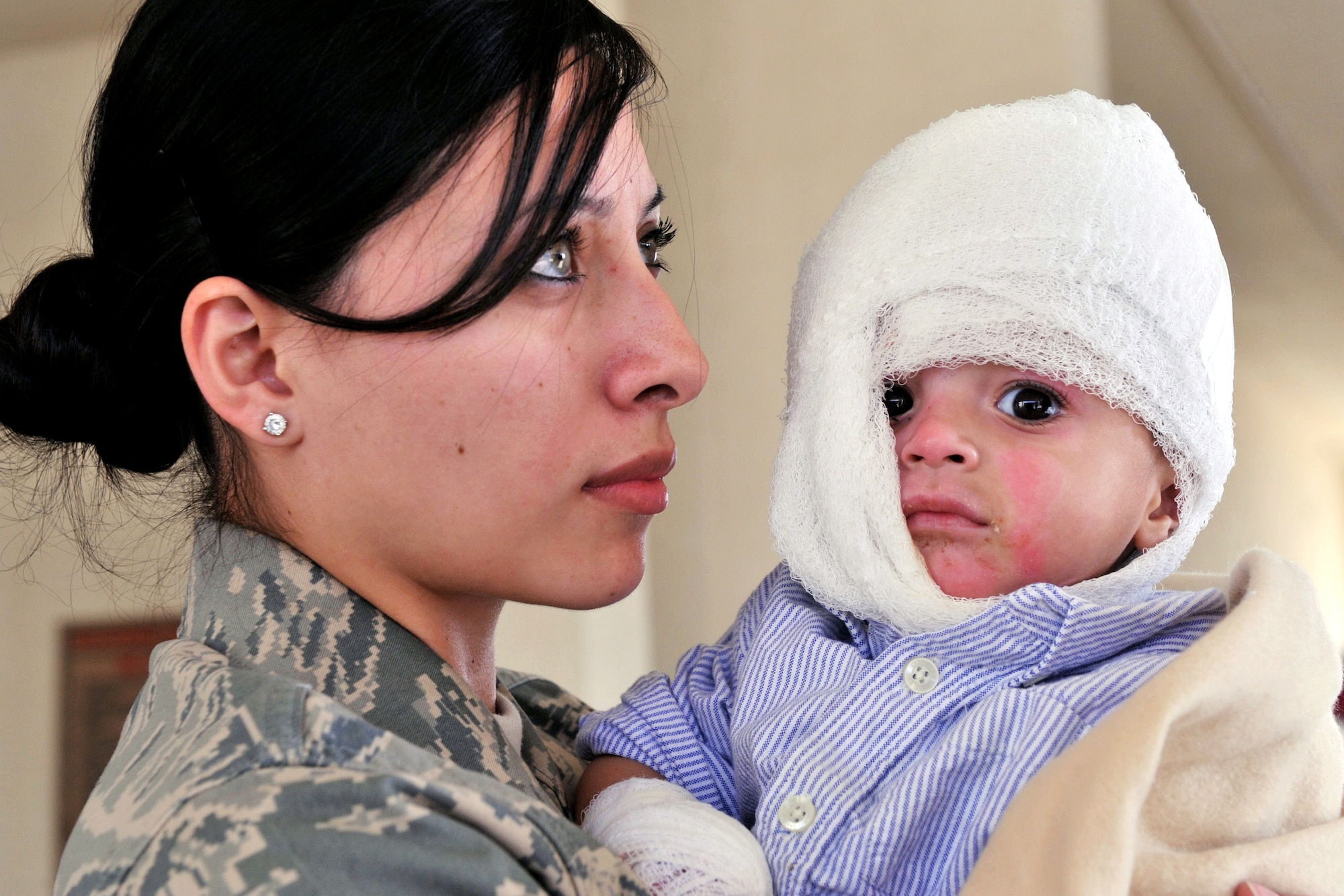 Senior Airman Mabel Aguirre and Ajamal Hazrat wait for transportation Jan 11, 2011, at the Craig Joint Theater Hospital at Bagram Airfield, Afghanistan.  Ajamal and several of his family members were injured after a propane tank used to heat their home exploded. Airman Aguirre is a medical technician with the 455th Expeditionary Medical Operations Squadron. (U.S. Air Force photo/Senior Airman Shelia deVera)