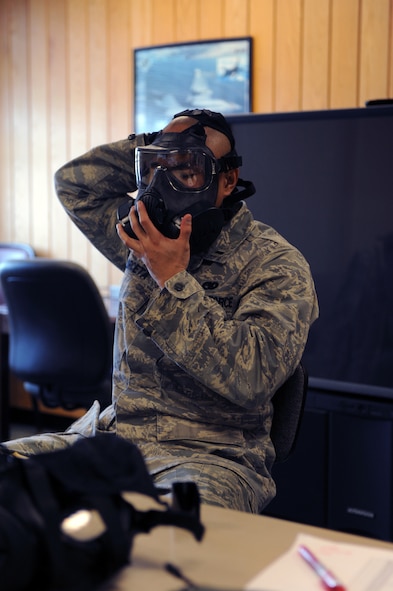 MINOT AIR FORCE BASE N.D. -- First Lt. Jon Arceta, 5th Logistics Readiness Squadron installation deployment officer, demonstrates the proper placement of the M-50 gas mask, here Jan 5.  Minot Air Force Base is the first base in Air Force Global Strike Command to receive and issue the new M-50 gas mask. (Air force photo/Airman 1st Class Aaron-Forrest Wainwright)