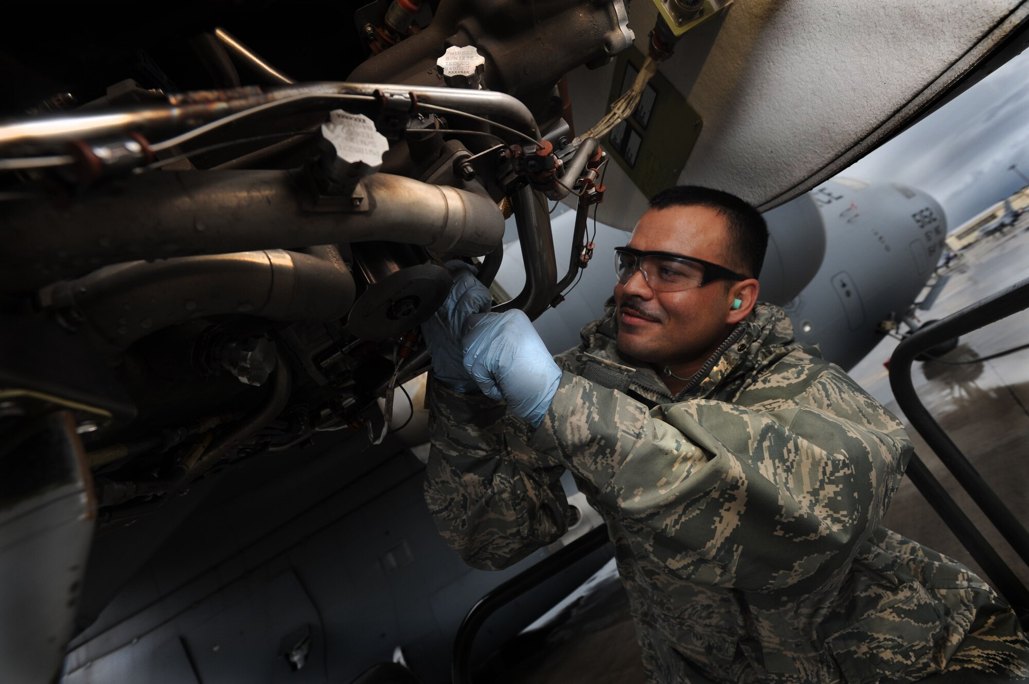 Staff Sgt. Manuel Garibay, a hydraulics craftsman with the 15th Aircraft Maintenace Squadron, replaces the hydraulic engine pump on a C-17 Globemaster on the 15th Wing flightline Jan. 12. Despite the harsh conditions and severe thunderstorm warnings, the 15th AMXS continued to work to keep the mission going. (U.S. Air Force Photo/Airman 1st Class Lauren Main)