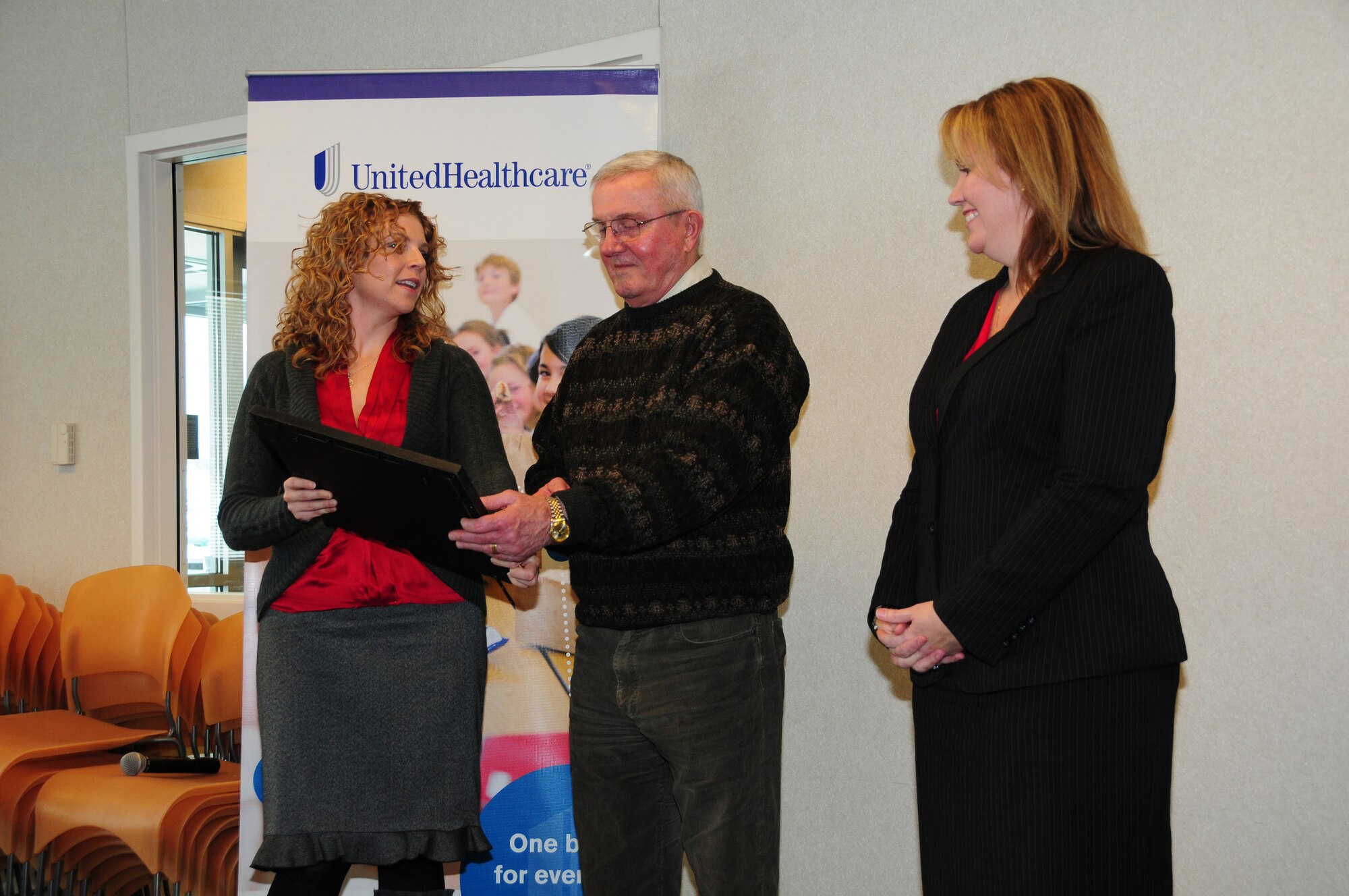 Senior Airman Teri L. Eicher (left) presents the Patriot award to UnitedHealthCare's regional manager Reid Olson as Amy Fisher, senior regional director for UnitedHealthCare looks on.    (U.S. Air Force photo by Master Sgt. Ralph J. Kapustka)  (Released)