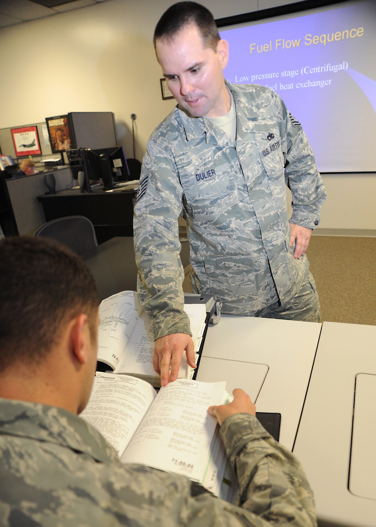 Tech. Sgt. Dustin Dulier, 373rd Training Squadron, Det. 8, KC-135 Stratotanker aerospace propulsion instructor and productions superintendent, helps a student find information on fuel flow sequences for engines in a technical orders binder January 10, 2011, McConnell Air Force Base, Kan.  All courses at the 373rd TS are accredited through the Community College of the Air Force, and Airmen completing the classes are awarded credits toward their CCAF degree. The 373rd TS annually instructs more than 1,000 students.  (U.S. Air Force photo/Senior Airman Maria A. Ruiz)