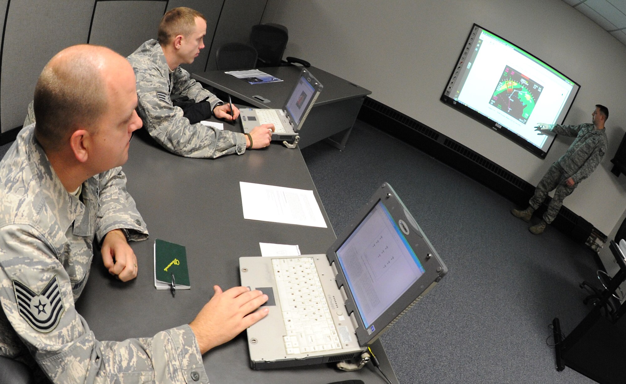 Staff Sgt. James Pope, 906th Air Refueling Squadron guidance and control technician, and Tech.Sgt. Russell Wilson, 6th Aircraft Maintenance Squadron guidance and control technician, review electronic technical orders while Tech. Sgt. Andrew Shepherd, 373rd Training Squadron, Det. 8, KC-135 Stratotanker instrument and flight control systems instructor, discusses flight displays, January 10, 2011, McConnell Air Force Base, Kan. Training classes at the 373rd TS vary from two days, to four weeks. The 373rd TS held 405 courses during 2010. (U.S. Air Force photo/Senior Airman Maria A. Ruiz)