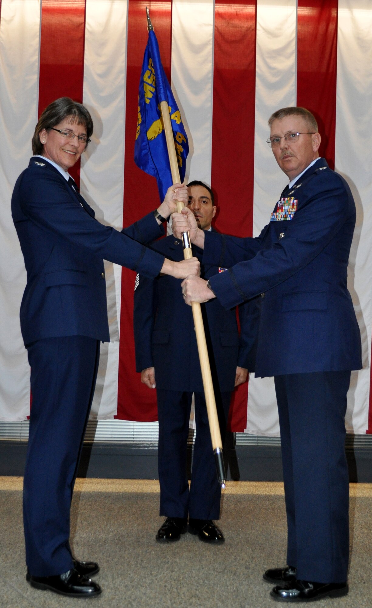 TRAVIS AIR FORCE BASE, Calif. -- Col. Nancy Brooks, commander, 349th Mission Support Group, and Lt. Col. Neal Landeen, 349th Force Support Squadron pose with the new 349th Force Support Squadron flag during a redesignation ceremony held here on January 8,2011. (U.S. Air Force photo/Senior Airman Amelia Leonard)