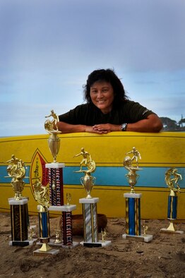 Master Sgt. Diane (Dee) Marques, 48th Aerial Port Squadron Air Transportation Craftsman sits on the beach with her surfboard and the trophies she has earned over the years. Sergeant Marques uses surfing as a means of fitness as well as relaxation. “Surfing is about laughing at yourself when wiping out on a wave,” she said. “It’s when you have a stressful day at work and you think about surfing to get away, no phone calls, peacefulness and waiting with friends at the line up to catch a wave.” (U.S. Air Force photo/Staff Sgt. Erin Smith)
