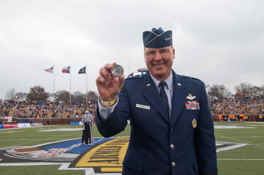 Gen. Craig R. McKinley, Chief, National Guard Bureau, displays the ceremonial coin used during the coin toss at Gerald Ford Stadium, Southern Methodist University, Dallas, Texas for the Bell Helicopter Armed Forces Bowl Dec. 30, 2010. The Army West Point Black Knights defeated the SMU Mustangs 16 to 14. (U.S. Air Force photo by Senior Master Sgt. Elizabeth Gilbert/released)