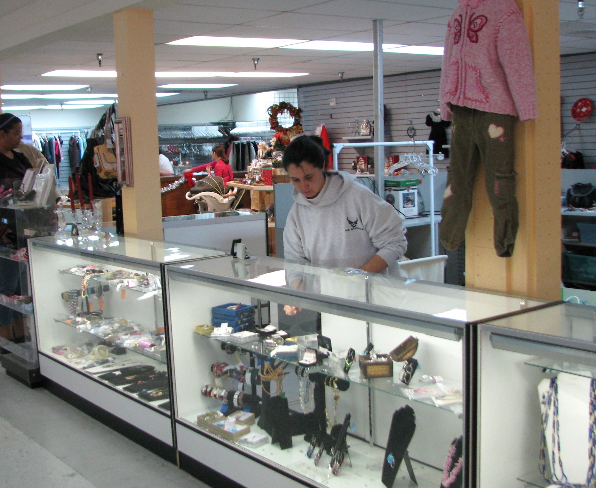 Thrift Shop volunteer Wendy Clouse artfully arranges jewelry in the shop's display case to entice customers. (Air Force photo by Diane Betzler)