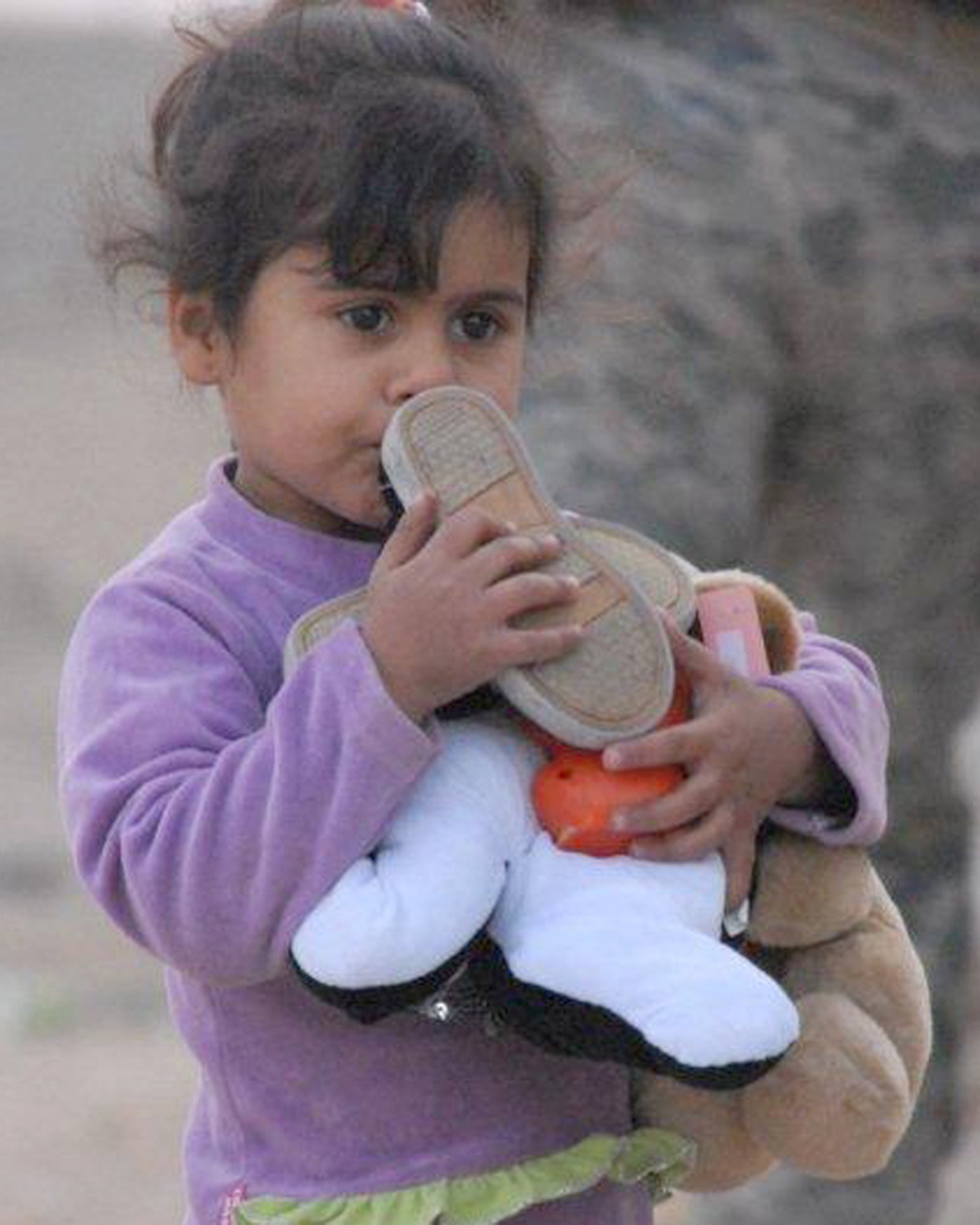 An Iraqi girl hugs the toys and shoes she received from the Echelon Above Division-Advise and Train team Dec. 16, 2010, at Ur Elementary School near Tallil Air Base, Iraq. Airmen assigned to the EAD-AT team handed out school supplies and toys to more than 70 children. (U.S. Army photo/Spc. Chastity Boykin)