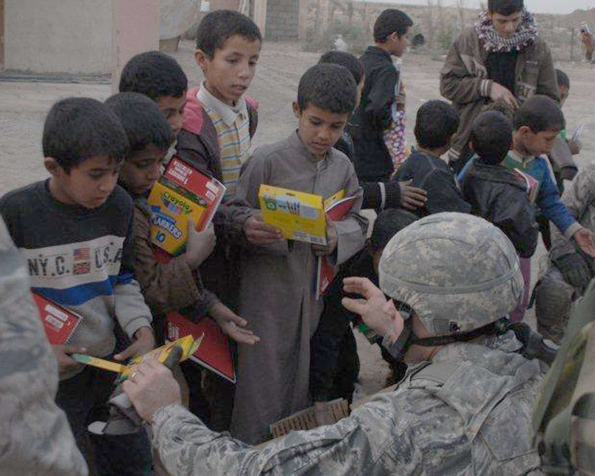 Master Sgt. Brent Baker hands markers and crayons to Iraqi children Dec. 16, 2010, at Ur Elementary School near Tallil Air Base, Iraq. Sergeant Baker is an Echelon Above Division-Advise and Train munitions adviser. (U.S. Army photo/Spc. Chastity Boykin) 